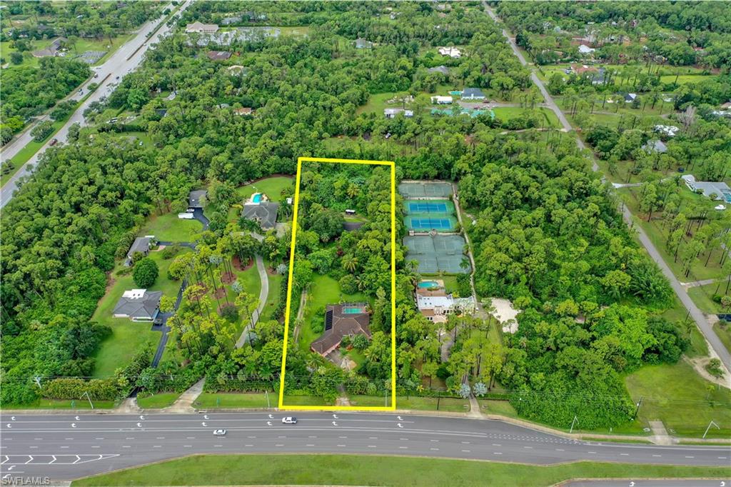 Rare find in Naples! Situated on over 3.5 acres this single family pool home & detached garage has a wonderful private oasis feel and offers a full circular drive that almost covers the entire acreage, large paved driveway leading to a 3-car garage on main house, tropical landscaping from front to rear, and a detached garage/shop w/ under air office space & a full bath. Perfect home for someone desiring Agricultural Exempt status and/or home based business that requires shop & land i.e. trucking, landscaping, construction. The main house offers a classic living & family room layout, spacious kitchen w/ service window to pool lanai & island, formal dining room w/ custom window seat, screened front entry w/ French doors to home, primary suite w/ tray ceiling & guest suite, surround sound system, and an extended screened lanai w/ heated pool, half bath, & long under truss sitting area. The solar system that heats the pool has been refurbished, a new well pump has just been installed, the 2 septic systems are regularly maintained, and the fridge is brand new. Fantastic Naples location-NOT in a flood zone- w/ easy access to I-75 and surrounded by lots of dining/shopping options.