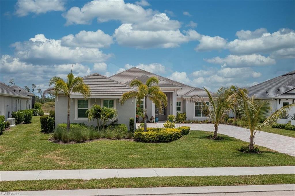 Exquisite 2024 Custom Luxury Residence in WILDBLUE – Southwest Florida’s Premier LAKEFRONT & BOATING Community

Experience unparalleled luxury living in the highly sought-after gated community of WildBlue, renowned for its breathtaking freshwater lakes, world-class amenities, and vibrant boating lifestyle. Built in 2024, this exceptional WCI Baneberry model showcases sophisticated design, premium upgrades, and an enviable southwest-facing exposure.

Offering 3 spacious bedrooms, a private den, and 3.5 beautifully appointed bathrooms, this residence features a thoughtfully designed split-bedroom floor plan and an expansive open-concept layout ideal for both everyday living and entertaining. The gourmet chef’s kitchen is a true centerpiece, complete with a gas cooktop, quartz countertops, custom white cabinetry, and premium finishes throughout.

The home is enhanced by elegant tile flooring, soaring volume ceilings, designer chandeliers and lighting fixtures, a custom entertainment wall with fireplace, solid-glass doors leading to the office, custom bathroom mirrors, and a well-equipped laundry room with built-in cabinetry and utility sink. Comfort is maximized with a dual-zone air conditioning system, including a dedicated unit for the owner’s suite.

Step outside to your private resort-style oasis. The expansive extended lanai features a fully equipped custom summer kitchen, covered outdoor dining area, heated saltwater pool and spa, oversized sun shelf, dramatic waterfall bowls, and panoramic picture-window screening that perfectly frames the outdoor living space.

Additional highlights include a spacious three-car garage with epoxy flooring, whole-home impact-resistant windows and doors for peace of mind, and negotiable designer furnishings for a truly turnkey opportunity.

Perfectly positioned within walking distance of the Amenity Center and waterfront restaurant, this home offers access to one of Southwest Florida’s most prestigious lifestyle communities. WildBlue spans approximately 800 acres of pristine freshwater lakes and over 1,300 acres of preserved natural beauty, allowing residents to enjoy boating, jet skiing, wakeboarding, water skiing, tubing, kayaking, and fishing directly from their backyard.

Residents enjoy an unmatched collection of resort-inspired amenities, including a luxurious clubhouse with fine and casual dining, resort and lap pools, poolside café, fitness and aerobics center, day spa, yoga lawn, tennis, pickleball and basketball courts, bocce ball, community boat dock with available slips, kayak launch, playground, private white-sand beach, and a dynamic social calendar. Optional golf memberships are available nearby for those seeking an even more elevated lifestyle.

This is more than a home—it is a rare opportunity to embrace luxury living at its finest.