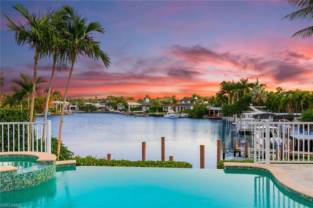 A distinguished luxury home, evoking an eastern seaboard charm, commands sweeping bay views overlooking Aqua Cove. This inviting residence radiates sophistication and individuality with paneled walls, transom windows, reclaimed heart of pine floors, and so much more. Encompassing over 5,500 sq. ft. of living area with appointed luxurious living spaces, including a living room, study, family room, loft, outdoor living room with a summer kitchen, and rooftop sundeck. High-end conveniences abound, such as a gourmet kitchen with a gas cooktop, formal dining room, fireplace, and reading loft. Completing the luxury experience, this property includes an elevator for easy access to all levels, ensuring convenience for all occupants. A stunning pool and spa, featuring an infinity-negative edge design overlooking the bay, providing a tranquil ambiance for relaxation and enjoyment amidst breathtaking views. The property boasts a dock with Gulf access and no bridges providing effortless access to the water. Every detail has been meticulously executed to create an architectural space that relaxes, comforts, and soothes the soul by invoking the best of traditional design with state-of-the-art technologies, crafting a timeless family retreat. Just two blocks to the beach and moments from 3rd Street South.