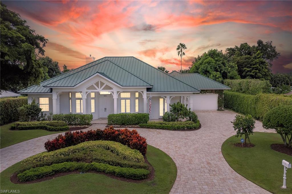 Welcome home, to your private oasis, right in the heart of Naples. This Mike Nourse-built home is an icon in the Moorings community, known for its curb appeal, impeccable construction, timeless architecture and expansive wrap-around porch. The generous lot is framed with 12-foot hedges, mature landscaping, swaying palms and is in the sought-after X flood zone. Inside, you are welcomed by soaring 10-foot to 14-foot ceilings, abundant natural light and a floor plan that easily accommodates everyone you care to invite. The chef’s kitchen is a standout, complete with quartz countertops, a spacious island, and top-of-the-line stainless steel appliances including a Sub-Zero fridge and Wolf gas cooktop. The primary suite is a serene retreat with tray ceilings, a spa-inspired bath, expansive windows that offer picturesque views and direct access to the lanai. Each of the four bedrooms have French doors that open to the lanai or porch. Plantation shutters throughout give the home an elegant, Old Florida feel. Step outside and enjoy Florida living. The calming sounds of the spillover spa create a tranquil experience as you lounge on the spacious lanai or float in the updated pool. Entertaining is a breeze with the fully equipped outdoor kitchen, covered seating and dining all on the screened lanai with plenty of fenced yard for your pet to play. Peace of mind is yours through the integrated security system, Wi-Fi-connected water heater, whole-house water filtration system and whole-house Generac generator, impact glass and storm shutters. No history of flooding, according to the owner. Just half a mile from the private Moorings Beach Club and the Moorings Golf & Country Club, this exceptional, impeccably maintained residence offers refined living, blending luxury and functionality in a prime location. Schedule a private showing today and make this coastal gem yours!
