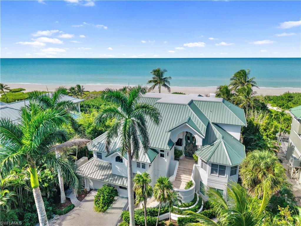 Fantastic Private Beachfront Sanctuary located on the Gold Coast of Captiva Island, where timeless craftsmanship meets coastal luxury. Framed by beautiful Royal Palms and lush, mature landscaping, this extraordinary estate is a rare opportunity to own one of Captiva’s most unique and artfully designed properties. A beautifully maintained private boardwalk winds through native foliage, offering quick and effortless access to Captiva’s world-renowned white sand beaches and turquoise waters. The oversized resort-style pool with integrated spa, and expansive covered lounge area creates the perfect environment for laid-back island living or upscale entertaining. Step inside through hand-crafted double doors by renowned sculptor Kim Brandell into a soaring great room, where floor-to-ceiling windows frame postcard-worthy views of the Gulf and surrounding nature. Natural light floods every corner, enhancing the home’s thoughtful architecture and elevated coastal feel. The gourmet kitchen is both functional and stylish, featuring high-end appliances, extensive counter space, a large walk-in pantry, and seamless flow into the main living areas. The spacious VIP suite offers the ultimate retreat—located just off the elevator, it features a private balcony, an expansive sitting/dressing room, floor-to-ceiling windows, and a luxurious bath complete with oversized shower, soaking tub, and custom mirrors. The home is spacious thru out offering private guest suites for your guest and family to enjoy. Additional highlights include concrete construction on pilings, estate zoning (with potential for additional dwellings), huge rec space, generous balcony and deck space on all levels, and panoramic Gulf views throughout. This is not just a home—it’s an experience. A rare blend of serenity, style, and superior design, tucked away in one of Captiva Island’s most coveted settings.