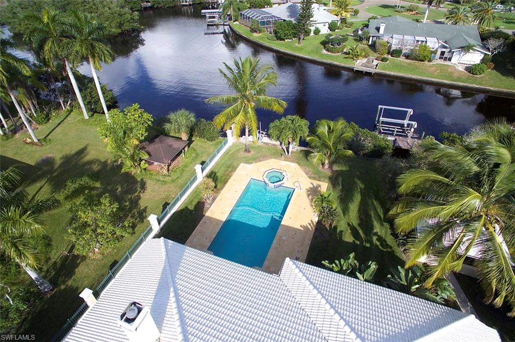 You can live large in this 2700+/- sq ft. 3 Bedroom, 3 Bath, Gulf Access Pool Home!  This remarkable home features 10' and 12' ceilings throughout with an open floorplan that includes Living Room, Formal Dining, Open Study, Family Room and split bedrooms with en suite Baths.  The focus is on Waterfront Living with 90 degree telescoping sliders that open to the Pool and Spa, beautifully landscaped yard, and Pavilion; with Basin and mangrove views beyond.  10k and 4k lb. boat lifts with electric and water - only a few minutes out to the Caloosahatchee River and down to the Gulf.  Great centrally located S. Ft. Myers neighborhood with no restrictions for parking your boat or RV.  Albastrino Marble walls & floors, Crema Marfil Marble floors, crown molding, 5 3/8" baseboard, tray ceilings, Mahogany wood flooring, Plantation Shutters,  & a Custom Coral wood burning fireplace add to the elegance of this home.  There's a Summer Kitchen on the travertine lanai and a free-standing pavilion for backyard BBQ's  - all within a completely fenced yard.  Enjoy watching Manatees, Dolphins, & all sorts of wildlife from either of your 2 docks. House is wired for a generator including transfer switch.