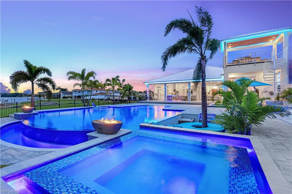 Spectacular Riverfront Estate: More than 1/2 acre lot (21,824sqf.) Discover unparalleled luxury in this stunning contemporary masterpiece situated on the prestigious Caloosahatchee River. This architectural gem seamlessly blends indoor and outdoor living, creating an extraordinary waterfront sanctuary. Distinctive Features Commanding river views from every major room 6 luxurious en-suite bedrooms including one separate guest suite including an office with separate entrance 6 bathroom plus a powder room and a full Cabana bath Soaring 14.5-foot ceilings throughout Smart home automation system with integrated Lutron LED lighting and Sonos sound system Electric shutters for ultimate security and convenience Statement pivot entry door with dramatic fire features Butlers kitchen Custom crystalo LED backlid wine cellar. Resort-Style Outdoor Living Spectacular saltwater pool with infinite edge, swim-up bar, sun shelf, and beach entrance Elevated spa with fire bowls Full outdoor cabana bath Professional outdoor kitchen featuring premium DCS appliances Elegant travertine outdoor flooring Meticulously landscaped grounds with mature palm trees and outdoor lighting State-of-the-art whole-house Sonos audio system Custom Lutron lighting design inside out Expansive pool terrace perfect for entertaining Garage & Storage: Oversized 6 car garage with 16' doors accommodating RV/boat storage with A/C Professional-grade car lift (8k pounds) Designer epoxy flooring in striking metro black and blue Additional storage level above garage(1,300 sq ft) Rod and reel storage Premium Finishes Imported large-format tile flooring Custom granite countertops and backsplashes Designer fixtures and appointments throughout Vapor fireplace Premium LED lighting system Super energy efficient Smart home with spray foam filled walls and complete house spray foamed roofs Perfect for the maritime enthusiast Direct Gulf access, catch Snook and Tarpon right in front of your Estate This extraordinary residence represents the pinnacle of modern waterfront living, where luxury meets functionality in perfect harmony. Every detail has been meticulously curated to create an unparalleled living experience.