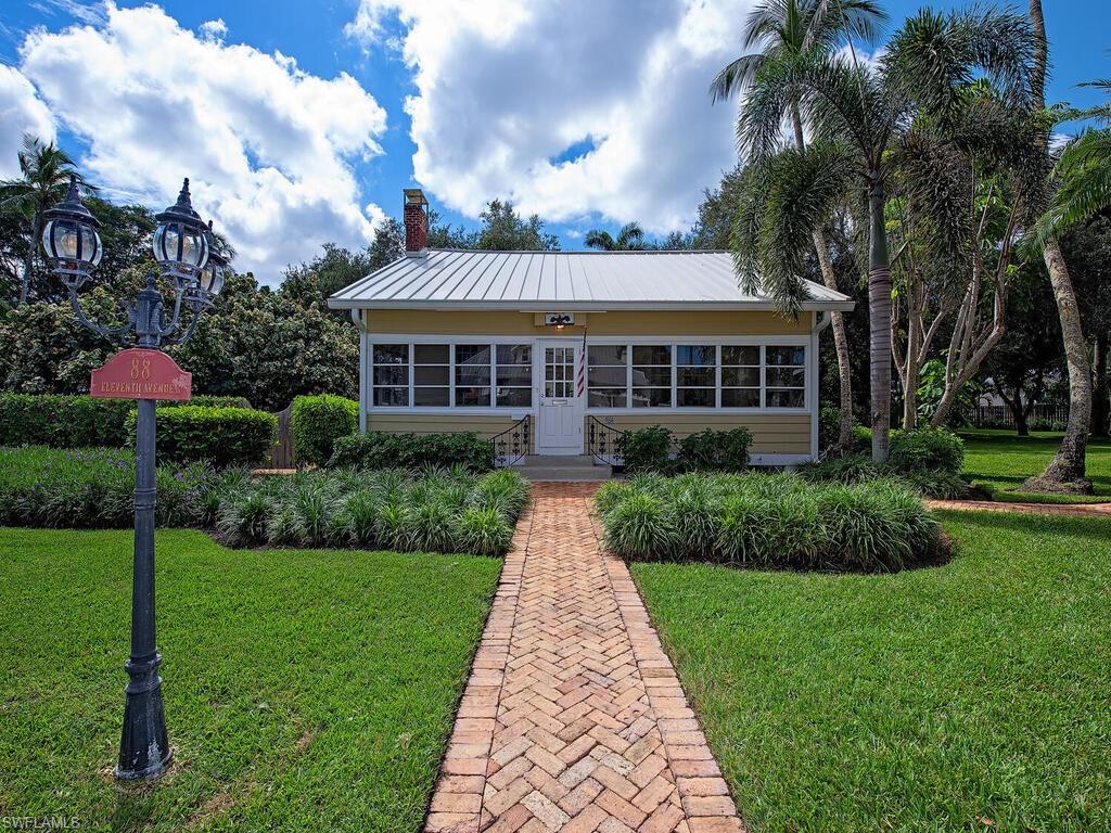 Nestled on the beach block right in the heart of Olde Naples, this historic Florida cottage offers timeless charm on a spacious 108'x 150' corner lot. Built in 1940 and crafted from locally milled heart pine and cypress, the home embodies the inviting coastal lifestyle that first drew families to Naples. Inside, a wood-burning fireplace warms the combined living and dining room, while French doors, vaulted ceilings, and a sun-filled solarium add character and comfort. The master suite includes a sitting room and library/media space, complemented by two guest bedrooms and a newly remodeled kitchen overlooking lush gardens. A detached garage with a one-bedroom guest apartment provides additional flexibility. With its enviable location on the beach block, this residence offers a rare opportunity to enjoy classic Old Naples living or to reimagine the site for a future luxury home.