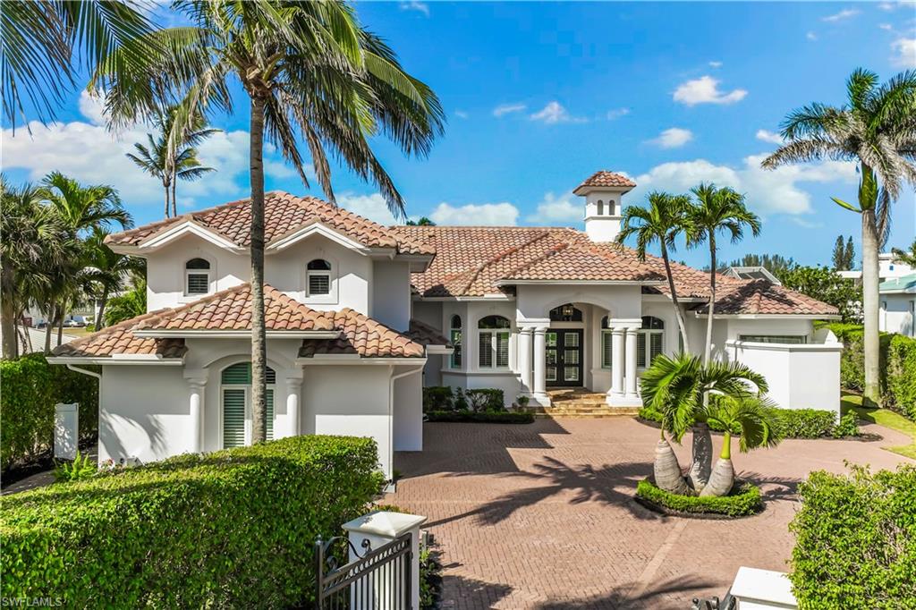Turnkey and truly spectacular, this waterfront estate offers 126 feet of pristine water frontage and an oversized dock! This is the opportunity you’ve been dreaming of—an elegantly updated, prestige Mediterranean-style residence featuring 4 bedrooms plus a den, 4 baths, and over a story and a half of luxurious living space.
Enjoy scenic western water views and an exceptional outdoor lifestyle with a lighted wrap-around walkway, 16,000 lb. boat lift, and quick, direct access to the Gulf of Mexico—just minutes away by boat. Enter through wrought-iron gates to a paved circular driveway and 3-car garage. Double doors lead into an elegant foyer flowing into sophisticated living and dining rooms. The superb island kitchen is appointed with Taj Mahal Quartzite countertops, brand-new Café appliances, a wet bar, dining buffet, and modern soft-close wood cabinetry. Luxurious finishes continue throughout: the master and guest baths feature Cristallo Quartzite, while the family bath highlights stunning Agate precious stone. Additional upscale amenities include COREtec luxury vinyl flooring, a Lumitron lighting system, tray ceilings, crown molding, and impact-resistant windows throughout. Private membership to the Moorings Beach Club is available, and with quick access to the world-class dining and boutique shopping of 5th Ave. S—plus the beach less than a mile away—you’ll experience the best of Naples living at your doorstep.