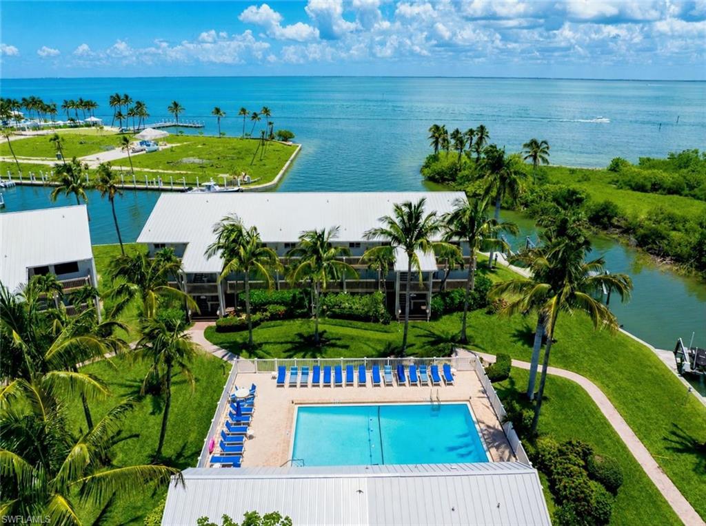 Front-Row Pine Island Sound Views at Marina Villas #905! Arguably the preeminent residence within Marina Villas, #905occupies a rare end-unit position with direct, unobstructed views across Pine Island Sound, framed by the marina basin in the foreground and pristine mangrove habitat along the opposite canal shoreline. From dolphins and manatees to the steady procession of boats traveling to and from the neighboring South Seas marina, the waterfront activity provides an ever-changing backdrop that is distinctly Captiva. Offered completely turnkey, this two-bedroom and two bathroom residence has been fully remodeled from top to bottom with a fresh, refined coastal aesthetic, island-chic finishes, and thoughtfully curated furnishings. The bright, open interior benefits from exceptional natural light and enhanced privacy, while all-new impact-rated windows, doors, and sliders provide added comfort and peace of mind. Marina Villas is a quiet waterfront enclave tucked away from the busier areas of South Seas, yet only a short and easy walk to the community’s deeded beach access. Residents and guests also enjoy a waterfront pool, while the property’s direct deep-water access places Pine Island Sound, the Intracoastal Waterway, neighboring islands, and some of Southwest Florida’s finest boating and fishing within immediate reach. Association-owned docks complete the waterfront experience, offering owners the opportunity to lease a boat slip when available and enjoy effortless access to the surrounding waterways. Whether enjoyed as a private island retreat or an income-producing vacation property, Marina Villas #905 offers an unmatched combination of turnkey luxury, end-unit privacy, effortless beach access, exceptional boating convenience, and what may be the finest view and waterfront position anywhere in the community. This is Captiva living with a true front-row seat.