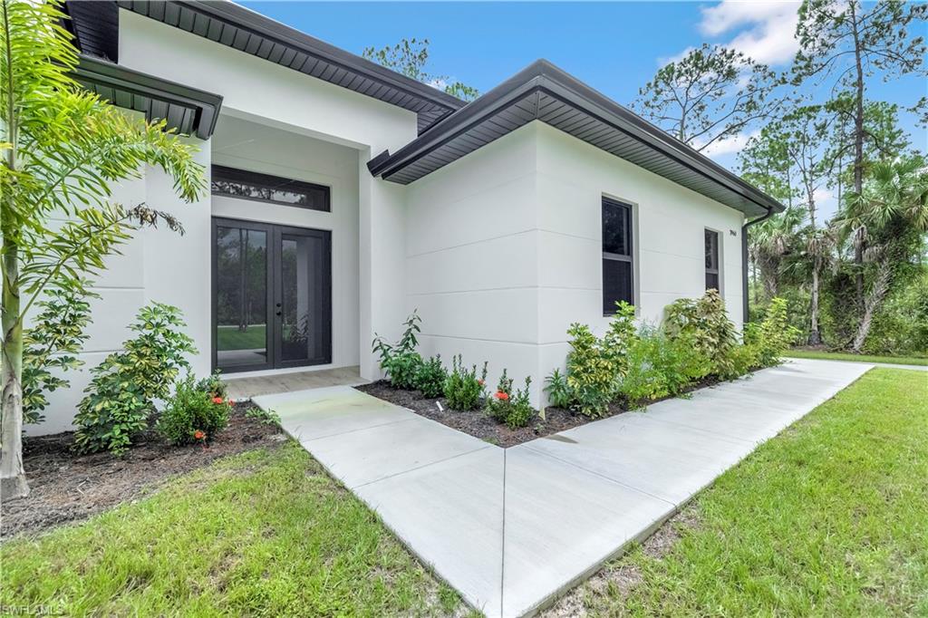 One or more photo(s) has been virtually staged, AI generated or rendered.  Amazing home being built in a 2.27 acres rare 100% upland lot, in the area of Golden Gate Estates, will feature 3 bedrooms + Den, 2.5 bath, & 2 car garage! Living area of 1,965 sq.ft and a grand total of 2,750 sq.ft. Upgrades include porcelain tile throughout, crown molding, quartz countertops, stainless steel appliances, and solid wood cabinets! The living room and master suite will boast tray ceilings. Master wing will feature an oversized bedroom, 2 spacious Closets, double vanity, and glass door enclosed shower. The outside of this home will not disappoint either with a Summer Kitchen and a beautiful landscape, auto sprinkler system, and a large lanai. Impact resistant windows/doors! Your brand new home will be ready in Setembro 2026! *Pictures are from another same model home*.