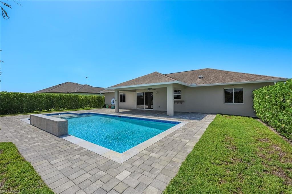 The perfect balance of modern luxury and country living awaits in this beautifully updated Golden Gate Estates residence, where over an acre of land provides the privacy, freedom, and space that's becoming increasingly rare. Set on 1.14 fully usable acres, this thoughtfully renovated 3-bedroom, 2-bath home showcases soaring vaulted ceilings, wide-plank luxury flooring, and an open-concept layout filled with natural light. At the heart of the home, the stunning new kitchen features quartz countertops, an oversized center island with abundant storage, custom shaker cabinetry, stainless steel appliances, and a timeless subway tile backsplash. The spacious great room flows seamlessly through sliding glass doors to an exceptional outdoor living area. The backyard is a true private retreat, highlighted by a brand-new custom pool complete with a sun shelf, cascading waterfall feature, expansive paver deck, and covered lanai—creating the ultimate setting for relaxing, entertaining, and enjoying Southwest Florida's year-round sunshine. Beyond the pool, the fully fenced property offers endless possibilities with room for pets, gardens, recreational vehicles, or future additions. A charming chicken coop adds to the property's estate lifestyle, allowing you to enjoy the best of country living without sacrificing modern comforts. Ideally located in Golden Gate Estates, this move-in-ready home offers the peace and privacy of acreage living while remaining just minutes from shopping, dining, top-rated schools, and everything Naples has to offer.