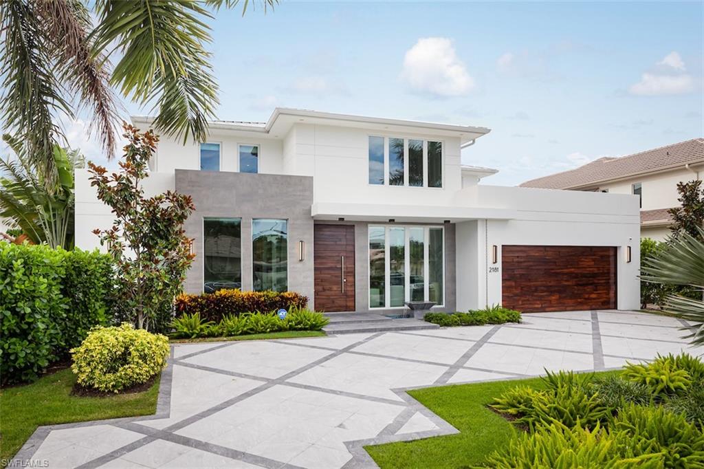 Stunning contemporary waterfront Estate Home off Naples Bay offers world class unimpeded boating to the Gulf and minutes to 5th Avenue downtown Naples! The Concrete Block home offers state-of-the-art technology, wide plank wood floors, exotic stone surfaces, and exquisite lighting. Luxurious stacked wood doors set the tone, and you feel the Zen tranquility of the flowing water bowl at the entrance.  21ft ceilings grace grand entertaining for dining or whatever you can imagine for this impressive space! A glass wine wall with Onyx lit Bar sets the stage for the great room with walls of glass overlooking a resort saltwater pool and spa. A large first floor primary suite includes a wet bar, safe room, stunning spa bath, outdoor privacy deck, two great closets, and a lovely water view.  The "smart" kitchen offers unique frig, 43" sink, 2 dishwashers, pantry room and a huge laundry leading to a 3 car garage with room for lifts. A large media loft with wet bar serves the 3 second floor en suite bedrooms, 2nd laundry, and balcony! Add a 20,000# Boat Lift, Jet Ski platform, new Seawall, deep water, Teak Deck, Outdoor Kitchen, Fire Pit, Pool Bath, Outdoor Shower leave nothing to be desired!