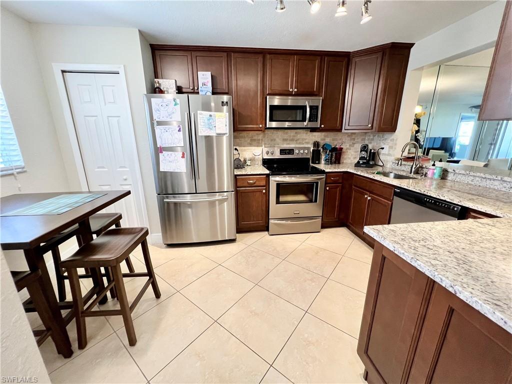 Nicely updated First floor 2 bedroom/2 Bath condo located in heart of Naples at Newcastle within Berkshire Lakes Community. Open floor plan featuring 18x18 cream colored porcelain tile on a diagonal in main living areas. Neutral carpets in bedrooms. Eat-in kitchen with wood cabinets, slow close drawers, granite counter tops with marble back-splash, lazy susan and stainless steel appliances. Master and guest baths feature wood cabinets, granite, tile accents. Master Bath has frame-less glass shower enclosure. Hurricane Shutters throughout. Full size laundry. Minutes to downtown, 5th Ave Shopping District & Beaches. Short walk to Newcastle community Pool, and short drive to larger Berkshire Lakes Clubhouse/Pool, recreational facilities which includes tennis courts, several large lakes, walking paths, tennis courts and lots of social activities!. Great for year round living, Snow bird and or investor.  Furniture negotiable!