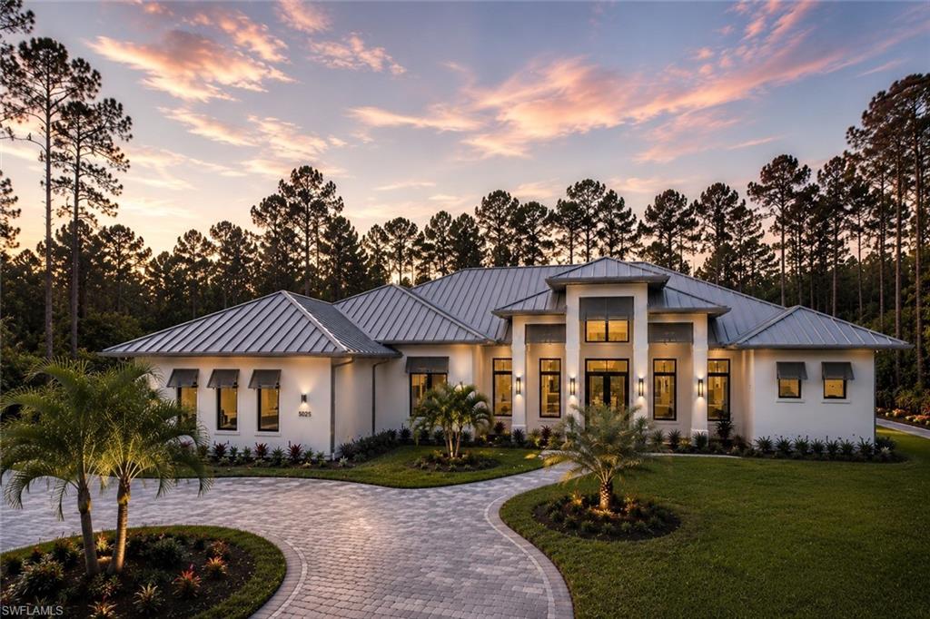 Now fully furnished! Experience elevated modern living in this newly constructed luxury estate situated on 2.73 acres of 100% upland in Logan Woods, surrounded by tranquil views, a circular driveway, and lush natural landscaping creating exceptional privacy and a true luxury retreat atmosphere.

The expansive open-concept floor plan is highlighted by dramatic tray and beam ceilings, oversized impact-resistant windows and doors, wood-look porcelain tile flooring, designer lighting, and a built-in wet bar complete with a wine cooler and illuminated floating shelving. The main living area centers around a sleek modern fireplace and flows effortlessly into the gourmet kitchen and outdoor entertaining spaces.

Designed to impress, the chef’s kitchen features custom floor-to-ceiling cabinetry with illuminated glass display cabinets, a premium Fisher & Paykel appliance package, double wall ovens, a gas cooktop with pot filler, quartz countertops, and a massive waterfall island. An oversized pantry, mud room, and spacious laundry room with abundant cabinetry and workspace provide additional functionality.

The primary suite offers a true spa-like experience with oversized dual vanities, a walk-in shower with dual rainfall shower heads, a freestanding soaking tub, private water closet with smart toilet, and a spectacular boutique-style custom walk-in closet complete with a center island and built-in storage.

Step outside into your private resort-style oasis featuring a panoramic screened-in pool and spa with a sun shelf, water features, outdoor fireplace, and a fully equipped summer kitchen designed for year-round entertaining.

Additional upgrades include a metal roof, tankless water heater, whole-house reverse osmosis system, spacious guest suites, and flexible living spaces ideal for an office or additional bedroom use.

Located just minutes from Naples shopping, dining, schools, and beaches, this exceptional property delivers luxury estate living with the privacy, flexibility, and space Logan Woods is known for — all with no HOA restrictions.