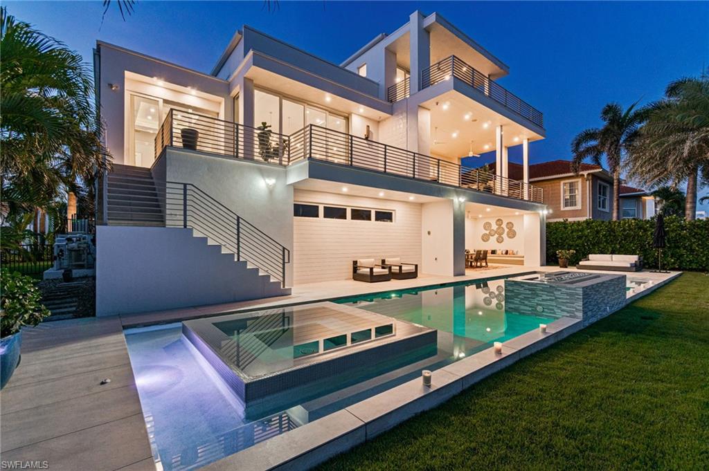 Experience the pinnacle of coastal luxury in this architecturally modern waterfront pool home featured in Gulfshore Life Magazine. Boasting over 4,000 square feet of sleek, open-concept living space, this exceptional residence is perfectly positioned just minutes from pristine beaches, upscale shopping, and fine dining.

Step inside to soaring ceilings, expansive glass doors, and seamless indoor-outdoor flow designed for effortless entertaining. The gourmet chef’s kitchen features top-of-the-line Wolf appliances, flush Neff custom cabinetry, and a waterfall island. Retreat to the expansive primary suite with spa-inspired bath with rain shower, soaking tub and back lit touch lights. Main outdoor living area features outdoor kitchen, dining and see thru fireplace that leads to another space to enjoy conversation, cocktails and sunsets. 



In total, this home has 6900 square feet of living space of which 4273 is under air offering 4/5 bedrooms (3 ensuite) and 4.5 baths. On the ground level is a private guest suite that leads to a covered lanai, sparkling 55 ft heated salt water pool with spa, sun shelf, and deck. The dock includes a 16,000 lb boat lift and a 10,000 lb jet ski lift. For the car enthusiast, there is a garage for 6 - 7 cars as well as ample storage for your beach and boating equipment. Complementing these amenities is a whole house generator with 1000 gallon propane tank. This home is truly a must see to fully appreciate the uniqueness of its design and the lifestyle it offers.