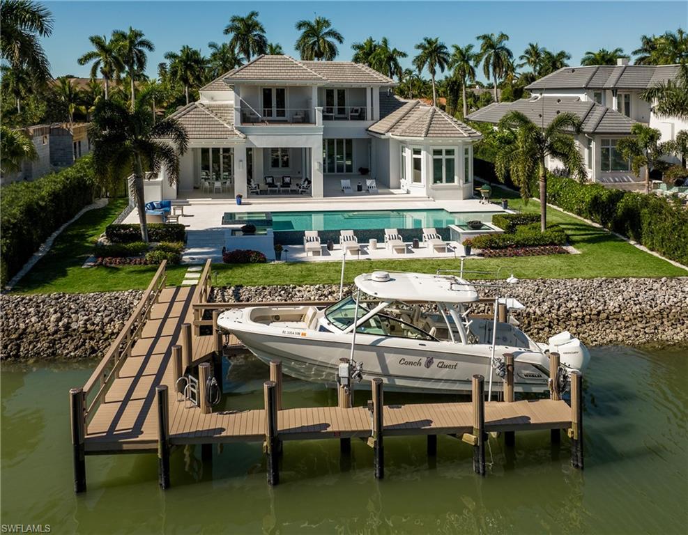 2017 built Port Royal Waterfront Home. This property features 100' of canal frontage w/ quick access to the gulf. The coastal contemporary home welcomes you into the stunning living/dining/kitchen/family great room framed by a wall of accordion doors that fully open to the expansive outdoor living area. The 6,874 sq/ft five bedroom plus office and den/salon includes Legno Bastone floors throughout.  The kitchen features two islands w/ quartz surfaces, extra fridge drawers, Miele appliances, wine cooler, and Butler’s pantry. The 1st floor master bedroom includes a bathroom suite w/ walk through shower, two commodes, soaking tub and California Closets.   You’ll also find a relaxing sitting area with beautiful morning light and water views. Upstairs you will find a gathering room with sunset terrace, three guest bedrooms, and a 2nd master suite that includes a huge sun deck overlooking the pool and canal. Also, the home includes a private elevator w/ garage, first and second floor levels, a second upstairs laundry, Lutron lighting, audio speakers throughout, security system, impact resistant glass, electric screens and hurricane protection. Port Royal Club membership eligible.