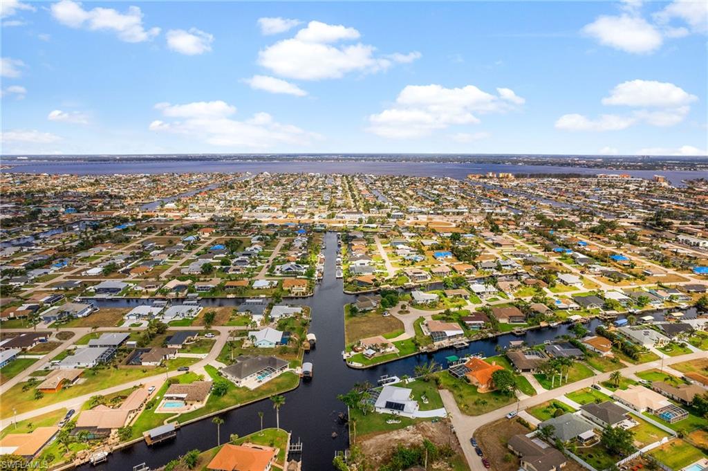 GULF ACCESS Waterfront Oasis!  Boasting over 230ft of Water Frontage on an Intersecting Cana. Airbnb already set up for you. This oversized lot offers Breathtaking Views and TWO Docks one with a Boat Lift, Screened Lanai with New Pavers, a Refinished Pool. The Easy Access to the Caloosahatchee River with only a short Boat ride makes this a Boaters Paradise. The Interior features are just as Impressive! Hurricane Impact Resistant Sliding Glass Doors that lead into an Open Concept Living Area Perfect for Entertaining. Custom Kitchen featuring an Island with Granite Countertops, Stainless Steel Appliances, Double Oven, and a small den/butlers Pantry that has a wine cooler making this Kitchen a Chef's Dream. The Spacious Primary Bedroom features Amazing Canal Views, a Custom En-suite Bathroom with Dual Sinks, Separate Tub and Shower, and a Walk-in Closet. Additional Bedrooms are Generously Sized and have Walk-in Closets with Ample Storage Space. The Stackable Washer and Dryer in the Laundry Room This is a rare opportunity to own a stunning waterfront property in Cape Coral, only 2 miles to Downtown Cape Coral and less than 11 miles to Downtown Fort Myers. Don't miss out!