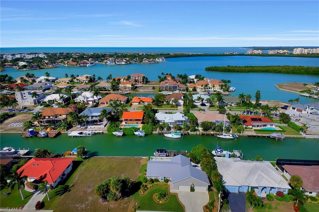 Enjoy the beautifully updated desirable Tigertail Beach residential area that gives quick and easy water direct access to the Gulf of Mexico from your large T-shaped dock with lift. This light and bright turnkey furnished four-bedroom, four-car-garage home boasts a brand-new kitchen which includes stainless steel appliances, breakfast bar, living and dining area, family room, remodeled baths, wood look vinyl flooring, special lighting and new impact glass windows and sliding glass doors.  Relax poolside on your open lanai with spa or lounge and linger on the lovely landscaped side patio. Start living the perfect island lifestyle today! This is a must-see, walk-through home and will not last. The front door, garage doors and side door are not impact glass.