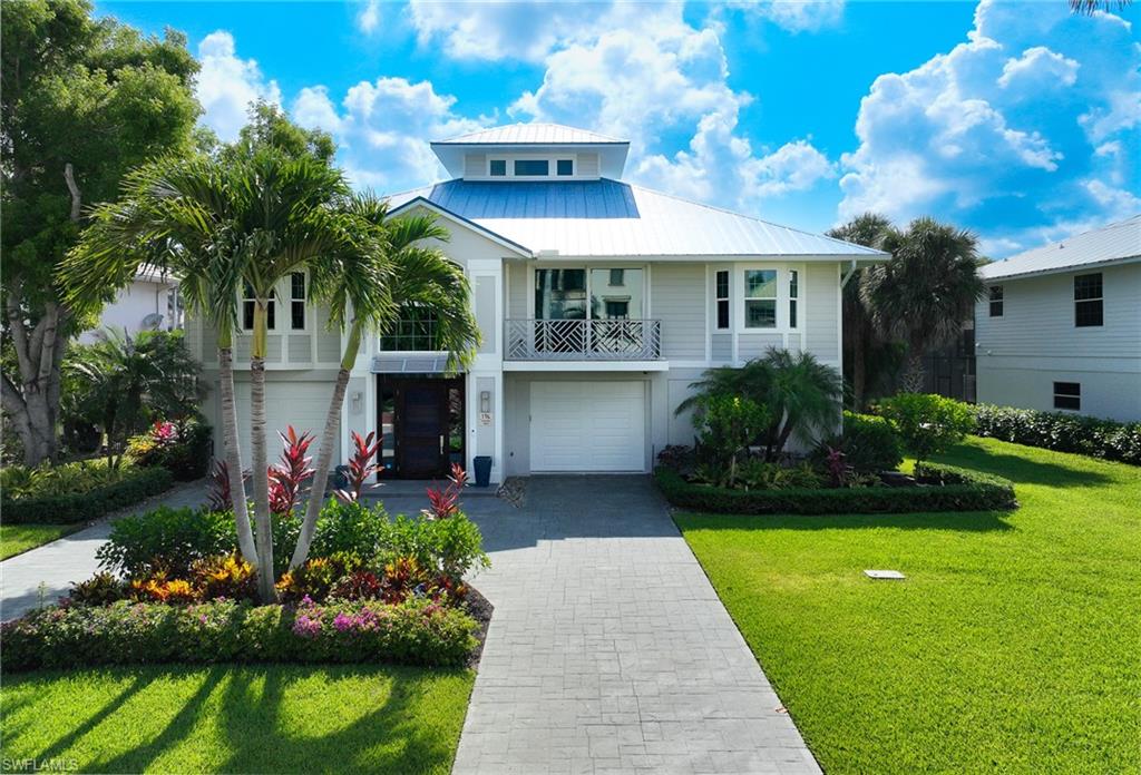 This beautifully renovated lite coastal lakefront home is located in double gated Southport on the Bay and within the beautiful community of Barefoot Beach. The home offers the best in Florida lifestyle including: just a short walk to the white sands of Barefoot Beach via one of two private beach accesses for Southport residents, the ability to rent a dock for your boat or jets skis for quick access to the Gulf of Mexico with no bridges and the enjoyment of your own tropical pool and spa with covered screened lanai right out your door overlooking the lake. With 6378 SQ Ft of entertaining and living space, 3538 AC space, and a spacious open floor pan with high vaulted ceilings, natural light throughout, all of which has been designed and finished to perfection - plus serene lake views from nearly every window. Amenities: a 2 story foyer with curved staircase with glass railings and custom wood treads, 5 bedrooms, 4 bathrooms, large covered lanai off great room and overlooking the pool and lake with horizontal gas fireplace, big screen tv, tongue and groove wood ceiling, a chef’s kitchen including custom white shaker cabinetry, professional grade appliances, full size wine refrigerator, gas range, quartz countertops, wide plank light oak flooring, extensive millwork/moldings throughout, custom built in’s with super large screen TV and electronics, walk up bar, large office area, flex room, gym/exercise area, lower level covered area leads to the oversized pool spa and screened lanai, impact windows & doors, metal roof, new whole house generator with 1,000 gallon propane tank, audio surround sound system & 3 A/C units. Designer furniture & furnishings negotiable. Barefoot Beach is one of Collier County’s finest gated beach communities and provides 24 hour guard patrols, one of the highest ranked beaches in the country and simply an awesome place to live. Option to join the Club at Barefoot Beach (located within the community) which offers casual and fine dining restaurants, pool & beachside food, drinks and chair service, indoor & outdoor bars, tennis courts with pro & a full events calendar.  (waitlist with limited usage during wait period).  Southport on the Bay in Barefoot Beach is centrally located to dining, entertainment, golfing, arenas in Naples and Bonita Springs and is close RSW Airport, the Promenade, Coconut Point, Mercato & Waterside Shops and Old Naples. If you are looking for an immaculate move in ready condition home that needs no work in Barefoot Beach - this is it.
