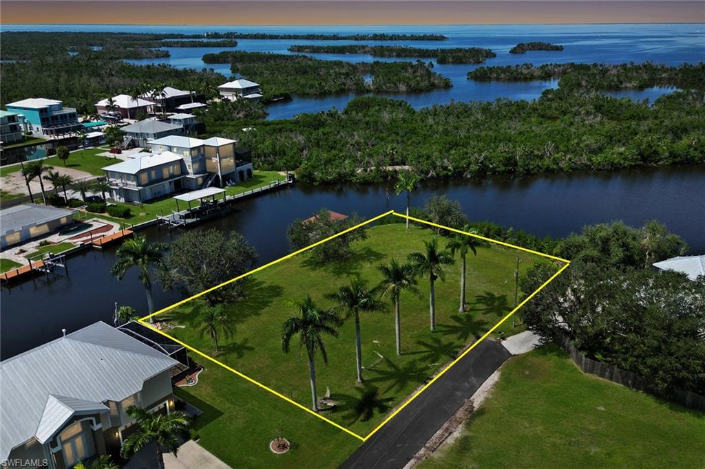 Discover a rare gem in the heart of Southwest Florida’s coveted Pirate Harbor community—a breathtaking half-acre lot that embodies coastal paradise. This oversized, tip-lot property, the only one of its kind available, boasts over 300 feet of pristine waterfront, offering unrivaled sailboat access to the open waters of the Gulf of America and beyond. Imagine casting off from your private dock, gliding effortlessly toward adventure, with the shimmering expanse of open water at your doorstep. Cleared with plenty of fill dirt on site, this stunning lot is a blank canvas ready for your dream home, where every day begins with serene water views and ends with vibrant, awe-inspiring sunsets. The natural beauty of Pirate Harbor surrounds you, with quick access to the region’s enchanting barrier islands—perfect for exploring hidden coves and pristine beaches. Whether you’re an avid boater, angler, or simply crave the tranquility of waterfront living, this lot delivers a lifestyle of unparalleled freedom and splendor. With the potential to split into two parcels, the possibilities are endless. Conveniently located just 15 minutes from Punta Gorda Airport, this slice of heaven combines seclusion with accessibility. Don’t miss this extraordinary opportunity to own a piece of Pirate Harbor’s coastal allure. Seller financing available with flexible, negotiable terms—inquire for more details. *Prior home on property demolished saving you money on impact fees*