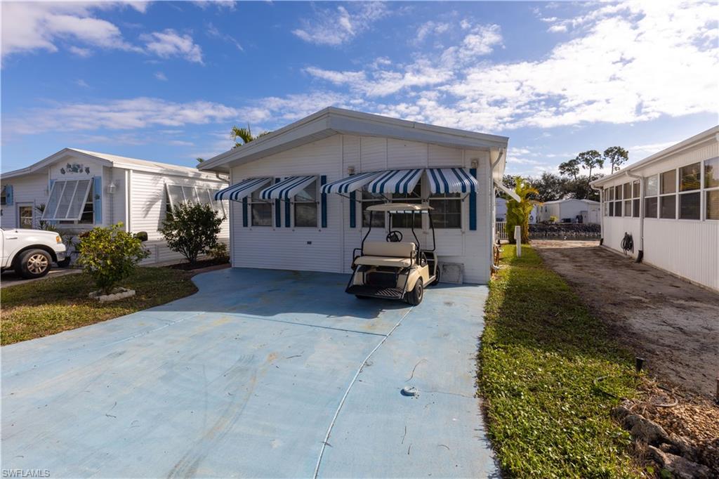 When you enter this beautiful home, the muted yellow tones will make you feel like you are bringing the sunshine with you. This home has so many plusses that you really have to see it. It is located directly across from the clubhouse so you have just a short walk to all the amenities. The screened in porch at the rear of the home offers a peaceful water view yet still has room for a good sized paver patio. The white safety fence on the edge of the patio adds to the charm. You will love the open floor plan with beautiful wood laminate flooring. It has a small workshop storage area. One of the big plusses is that there are no stairs once you enter the home.