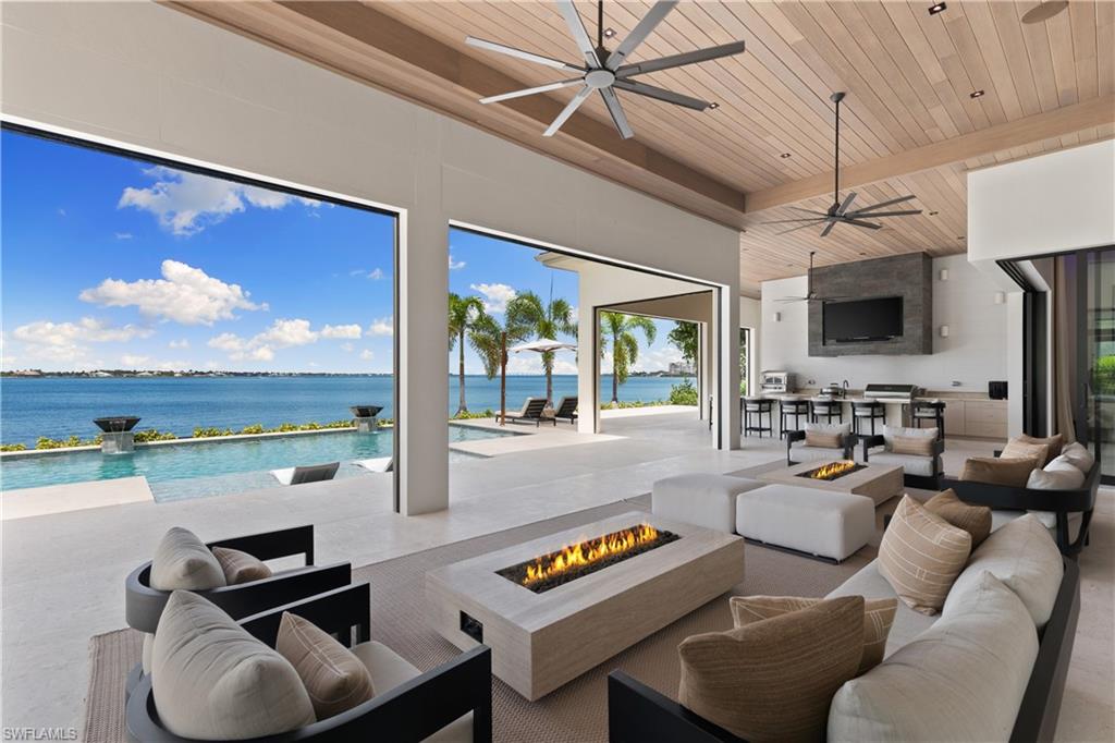 Embark on a journey of exquisite living in this unparalleled waterfront residence, a sanctuary of luxury in Gulf Harbour’s prestigious Edgewater subdivision on highly sought-after Longwater Chase Court. Exuding opulence at every turn, this home will impress even the most discerning buyer. Wide-plank White Oak flooring leads through grand spaces adorned with hand-selected Italian marble and refined details. The great room offers effortless entertaining with a built-in backlit Onyx bar, dual Sub-Zero wine storage systems, and a striking 12-foot water vapor fireplace illuminated by a hand-blown Restoration Hardware fixture. The expansive chef’s kitchen features premier Wolf, Sub-Zero, True, and additional high-end appliances, seamlessly integrated with a marble butler’s pantry complete with a coffee station, dual lazy Susans, second dishwasher, microwave, and Franke sink system.
The private primary suite provides sweeping water views and a spa-like bath. Three ensuite guest bedrooms ensure comfort and privacy, while an oversized water-facing bonus room—equipped with a king Murphy bed and queen sofa pullout—serves as a flexible retreat for additional guests, a home office, exercise space, or playroom. Cutting-edge smart technology elevates daily living with Loxone-powered Ketra lighting, Bowers & Wilkins in-ceiling speakers indoors and out supported by eight Sonos Amps, and fully integrated smart lighting, alarm, and climate systems. Outdoors, 110 feet of private white-sand beach and 1,400 sq. ft. of covered lanai living create a rare oasis with unobstructed Caloosahatchee River views. The saltwater pool features a built-in sun shelf, spa, and dramatic fire and water elements surrounded by lush landscaping—perfect for evenings under the stars. Ideal for boating and golf enthusiasts, Gulf Harbour provides a world-class deep-water marina with access from Sarasota to Marco Island and an acclaimed golf course with immediate memberships. A coveted D-Dock boat slip—along with a Boston Whaler 380 Realm—is available separately. Crafted by Frank Jenkins Custom Homes, this masterpiece represents the pinnacle of craftsmanship and Southwest Florida living, offering an extraordinary opportunity to move right into a one-of-a-kind waterfront oasis.