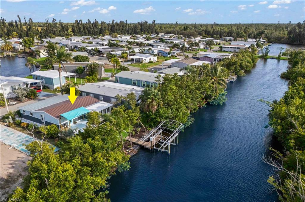 WELCOME TO YOUR WATERFRONT ISLAND PARADISE on Pine Island! Highly sought-after 55+ boating community of Pine Island Cove, this BEAUTIFULLY UPDATED, MOVE-IN-READY waterfront home offers the perfect combination of COASTAL CHARM, BOATING CONVENIENCE & RESORT-STYLE LIVING. Situated on scenic canal, this 2 BED + 2 BATH manufactured HOME features PRIVATE DOCK & 10K-lb BOAT LIFT, providing exceptional access for boating, fishing, kayaking & exploring pristine waters of Pine Island Sound, Matlacha Pass, Sanibel, Captiva, Cayo Costa, Boca Grande & beyond Gulf. Community boat lift allows convenient navigation from your backyard to some of SWFL's most desirable waterfront destinations. From the moment you arrive, you'll appreciate the home's inviting curb appeal featuring tropical landscaping, covered carport parking & a welcoming island-inspired exterior. Inside, the bright & airy floor plan is filled w/ natural light, enhanced by expansive waterfront windows that frame peaceful canal views throughout the main living areas. Spacious living & dining rooms create an ideal setting for entertaining family & friends while enjoying the beauty of Florida waterfront living. Vinyl flooring, coastal-inspired finishes, updated fixtures & tastefully renovated spaces create a comfortable, move-in-ready atmosphere. The kitchen offers cabinetry, stainless steel appliances, counter space, and breakfast bar seating. Primary bathroom features a stylish double-sink vanity with modern finishes, while both bedrooms offer comfortable accommodations for owners & guests alike. Outside to your PRIVATE WATERFRONT RETREAT featuring a composite deck with shade sail, perfect for outdoor dining, grilling, morning coffee, or sunset cocktails while enjoying gentle island breezes. Mature palms, tropical landscaping, and lush greenery surround the property, creating exceptional wall privacy and a true backyard oasis. The beautifully maintained lawn extends directly to the water's edge, where your private dock and 10,000-lb boat lift await just steps from the home. Residents of Pine Island Cove enjoy outstanding amenities including a COMMUNITY POOL, CLUBHOUSE, PICKLEBALL COURTS, DOG PARK, BOAT RAMP, BOAT STORAGE, SOCIAL EVENTS, and WATERFRONT RECREATION AREAS. This golf-cart-friendly community is known for its convenient access to local marinas, waterfront restaurants, live entertainment, art galleries, farmers markets, and world-class fishing. Whether you're searching for a year-round residence, winter retreat, or affordable waterfront getaway, this exceptional property offers the perfect blend of WATERFRONT LIVING, BOATING ACCESS, LOW-MAINTENANCE OWNERSHIP, and the laid-back island lifestyle that makes Pine Island one of Southwest Florida's hidden gems. LIVE WHERE OTHERS VACATION!