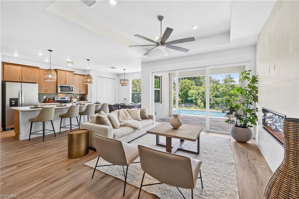 Not located in a flood zone, this exceptional new construction residence is set just minutes from historic downtown Fort Myers in the coveted Riverside enclave off McGregor Boulevard. A three-car garage provides added convenience and versatility, while a majestic mature banyan tree anchors the front approach, offering a rare sense of character and place that sets the stage for this refined Tribeca floor plan—where contemporary design meets effortless Florida living.

Inside, the home offers a serene view and an open, flowing layout designed for both elegant entertaining and everyday comfort. The gourmet kitchen serves as the centerpiece of the home, appointed with quartz countertops, 42-inch custom cabinetry, stainless steel appliances, a designer tile backsplash, and an expansive center island ideal for gathering.

The spacious great room, anchored by a fireplace, connects seamlessly to the main living areas, enhancing the home’s natural openness and livability. The private owner’s suite is a serene retreat, featuring a large walk-in closet along with a second additional closet, and a spa-inspired bath with dual vanities and refined quartz finishes.

Throughout the residence, 8-foot interior doors and curated designer lighting reinforce the home’s elevated aesthetic. Hurricane-impact windows provide added security and peace of mind, while a 2-10 Home Buyers Warranty is included for confidence in ownership.

Outdoors, a private pool and beautifully landscaped backyard create a secluded retreat ideal for entertaining or quiet relaxation beneath the Florida sky.

Perfectly positioned within walking or biking distance to the Fort Myers Country Club and just moments from the Caloosahatchee River, sandy beaches, boutique shopping, dining, and the vibrant downtown river district. Nearby landmarks include the historic Edison and Ford Winter Estates, adding to the home’s unmatched sense of location and heritage.

A rare opportunity to own new construction in the heart of the McGregor corridor—where architectural sophistication, natural beauty, and timeless charm converge.