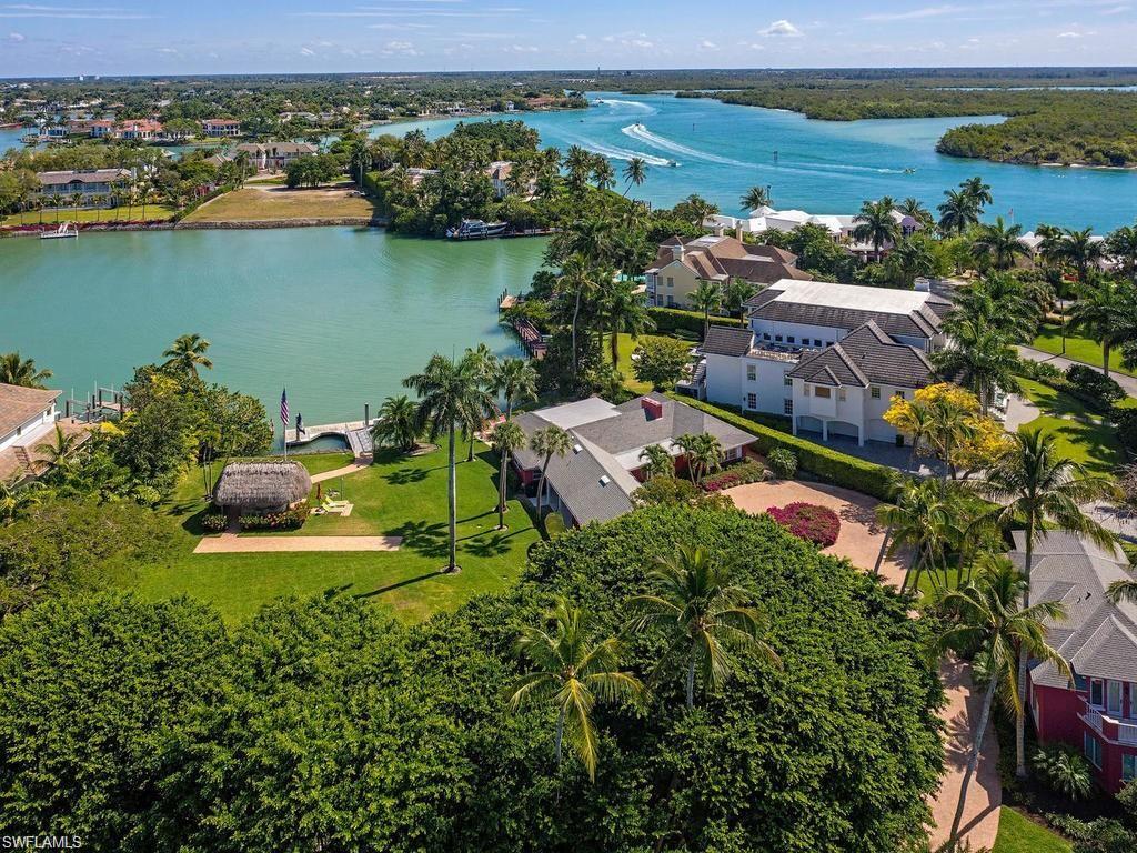Outstanding opportunity to purchase nearly an acre on the bay just around the bend to the Gulf of Mexico, in the ultra-luxe enclave of Port Royal. The two contiguous bay-front lots provide expansive water views and are home to an astounding 60 ft. floating deep-water concrete dock, chickee hut, four bedroom guest bungalow, separate carriage house with 2 additional bedrooms, kitchen and family room, and three indoor parking bays set amidst a canopy of majestic banyan trees.  Property being offered as is. Port Royal Club membership eligibility.