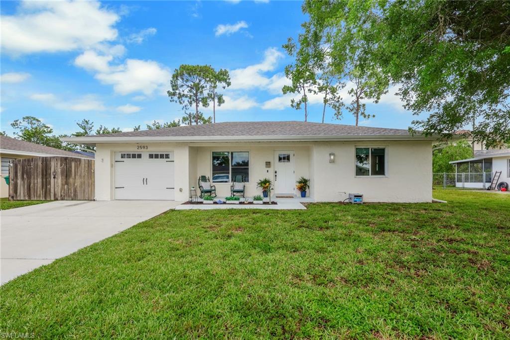 Luxury meets timeless charm in the heart of Naples, where every room tells a story and every thoughtful update makes this beautifully reimagined home feel effortlessly inviting. Nestled in the highly sought-after Poinciana Village, this meticulously maintained residence is the perfect blend of modern coastal style, everyday comfort, and exceptional value—offering first-time homebuyers, seasonal residents, or anyone looking to establish roots in one of Naples' most desirable locations an opportunity that's truly move-in ready.

From the moment you arrive, you'll appreciate the home's welcoming curb appeal, mature shade trees, and inviting front porch. Inside, warm luxury flooring, crisp designer finishes, custom millwork, updated lighting, and a bright, airy color palette create a home that feels both sophisticated and relaxed. Every space has been thoughtfully refreshed while preserving the warmth and character that make this property so special.

The beautifully updated kitchen is both functional and stylish, featuring gleaming white cabinetry, solid surface countertops, glass-front display cabinets, pristine appliances, and an abundance of natural light. Just beyond, the spacious screened lanai extends your living space outdoors, creating the perfect setting for morning coffee, weekend barbecues, or relaxing evenings under the twinkling café lights.

The bathrooms have been tastefully renovated with designer-inspired finishes, including custom vanities, elegant tile work, matte black fixtures, floating wood shelving, and spa-like details that elevate everyday living. Each bedroom offers generous space, updated ceiling fans, and inviting natural light, creating peaceful retreats throughout the home.

Step outside to discover one of this property's greatest features—a fully fenced backyard with endless possibilities. Whether you envision a custom resort-style pool and spa, a lush tropical garden, an outdoor kitchen, or a play space for family and pets, this oversized yard provides the ideal canvas to create the backyard oasis you've always imagined.

Perfectly positioned in the established Poinciana Village neighborhood, you'll enjoy the convenience of being just minutes from Downtown Naples, Fifth Avenue South, world-renowned Gulf beaches, shopping, dining, top-rated schools, and everyday conveniences. Combining designer updates, undeniable character, meticulous care, and an unbeatable Naples location, this is the kind of home that captures your heart the moment you walk through the front door—and one you'll be proud to call your own.