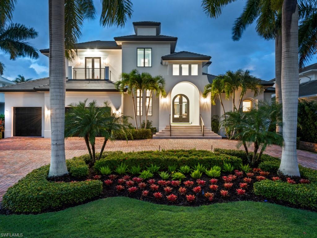 H.16462 - LIKE BRAND NEW! Extensively renovated in 2020 by Canada Design Group, this magnificent home offers resort style living with views of Naples Bay and a short walk to 3rd St shopping and white sandy beaches. The two-story home features 5,545 SF with an open floor plan and 5 ensuite bedrooms and 5 ½ baths, including two first floor master suites and an elevator. Hand scraped walnut wood floors throughout. Disappearing sliders open to extensive outdoor entertaining areas with 11,316 SF of true indoor/outdoor living.  The professional chef’s kitchen includes an oversized quartzite waterfall island and Wolf and Sub Zero appliances.   The covered outdoor area includes a kitchen and bar, gas fireplace and automated screens and shutters, along with a pool and spa with quick heating technology.  A 13,000 lb covered boathouse and 40’ yacht dock have direct access to Naples Bay.  The second floor includes an office, exercise room, family room and outdoor entertainment area with views of Naples Bay. 3rd floor sun deck for watching sunsets and fireworks.  A 3-car garage with room for lift, and an extra storage garage for kayaks/ boating equipment. Impact windows and doors throughout.