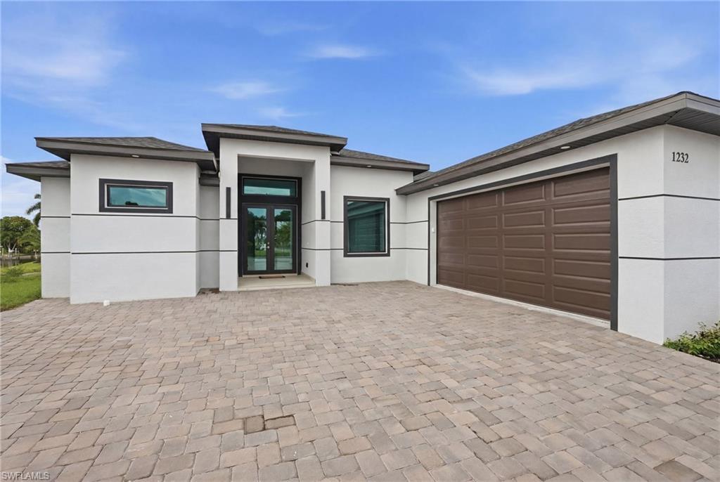Welcome to this stunning new construction home offering modern luxury, thoughtful design, and freshwater canal access to Shamrock Lakes. This beautifully crafted 3-bedroom, 2-bathroom home with a den features an open-concept layout, soaring ceilings, and tile flooring throughout. The chef’s kitchen showcases quartz countertops, a large waterfall island, soft-close cabinetry, and stainless steel appliances. The private primary suite offers two walk-in closets and a spa-inspired bathroom complete with dual vanities, a freestanding soaking tub, and a spacious walk-in shower. Both guest bedrooms also feature walk-in closets, providing exceptional storage throughout the home. Step outside to your covered lanai featuring a built-in outdoor kitchen overlooking the private pool and freshwater canal. Additional highlights include impact-resistant windows and doors, a paver driveway, a spacious laundry room with utility sink, and a two-car garage. Conveniently located near shopping, dining, schools, and all that Cape Coral has to offer, this exceptional home combines luxury finishes with the relaxed Florida lifestyle. ALL ASSESSMENTS PAID.