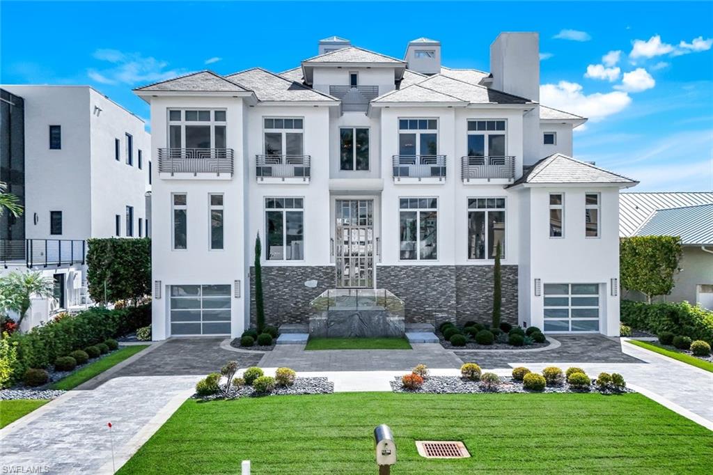 This one-of-a-kind waterfront masterpiece at 260 Channel Drive defines Naples coastal living at its finest. Walk to the powder-white sands of Vanderbilt Beach and enjoy having your boat right in your backyard for effortless Gulf access. Designed for those who appreciate exceptional craftsmanship and cutting-edge architecture, this residence blends glass, steel, and natural light into a breathtaking modern statement.

Four levels of inspired design showcase panoramic bay views through walls of glass and expansive terraces that capture the essence of indoor-outdoor living. The exterior sets a bold tone with a granite paver driveway, a 3-car garage featuring frosted glass doors, stainless balcony railings, and a striking glass-and-steel staircase.

Step inside through a 12-foot Tiffany-inspired stainless-steel entry door to discover a luminous interior wrapped in pure Thassos marble floors and anchored by a dramatic glass staircase framed in Macassar wood. The gourmet Allmilmo kitchen—crafted in Germany—is paired with Miele and Gaggenau appliances, dual dishwashers, dual laundry sets, and a temperature-controlled wine cooler, blending form and function seamlessly.

Every detail reflects European precision and design, from the custom Bartels German interior doors to the Bisazza mosaic tile bathrooms in each ensuite. The primary suite elevates luxury with gold-leaf Bisazza tile and sweeping bay views. A state-of-the-art cinema room offers a 120” screen, 3D anamorphic projector, Bang & Olufsen sound, and Swarovski crystal lighting for an immersive experience.

Additional features include an elevator with Swarovski accents, Crestron home automation, and a LightTouch lighting system throughout. The lower level provides a versatile living area with a steam room and direct access to the pool and dock—ideal for guests or a private wellness retreat.

Perfectly positioned along the three finger streets in Connors off Gulf Shore Drive, this south-facing residence captures all-day sunlight and the rare combination of beachside convenience and boating luxury. Just steps to Vanderbilt Beach and LaPlaya Beach & Golf Club, and a short drive to The Ritz-Carlton, as well as the upscale shops and dining at Mercato and Waterside Shops, 260 Channel Drive delivers the ultimate Naples lifestyle—where modern design meets coastal serenity.