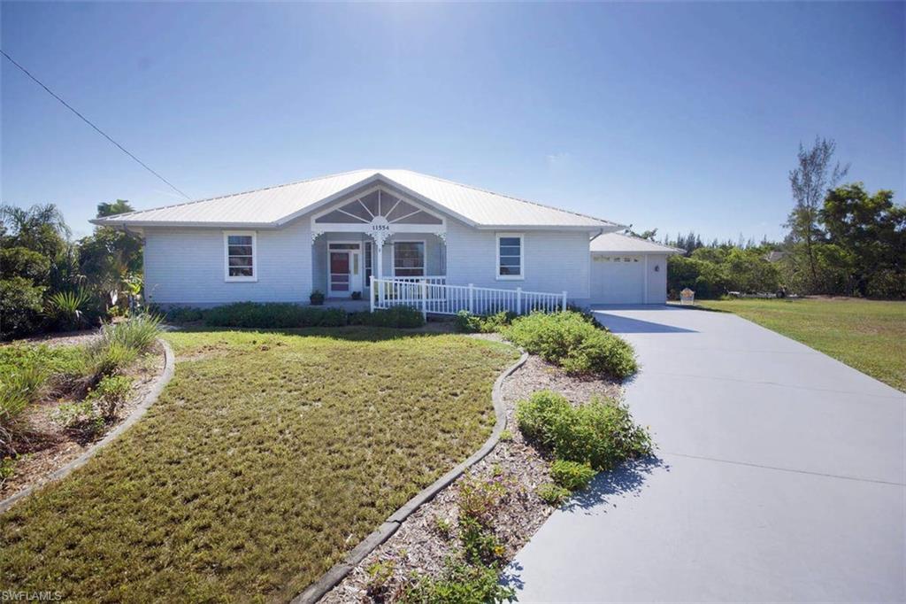 Florida Style family home is nestled on a quiet culdesac only a few minutes by boat to Pine Island Creek and Charlotte Harbor.  Less than 2 miles North of Pine Island Center, it is a quick trip off island although you get to enjoy this unique Island lifestyle.  You will love this efficient split floor-plan that includes 4 bedrooms, 3 full bathrooms and a den within the 2035 sq/ft AC living space. The home features ten ft ceiling, 8 ft sliders, hard wood  and tile floors, stainless steele appliances and plenty of cabinet space. Large master bedroom and bath is a must see. Outside you will love the look of the tin roof and appreciate the large lot that will easily accommodate a huge new pool.  The lush wall of mangroves provides an incredible amount of privacy in the back of the home. With 160 ft on the water, the possibilities for the water access are tremendous.  Trim or manicure the mangroves, install additional docking or simple kayak launching are only a few of the options. Ramp access to the front door is tastefully done and very convenient. City water IN and no assessments.  Close to everything, yet privacy galore.
You will not be disappointed you took the time to see it.