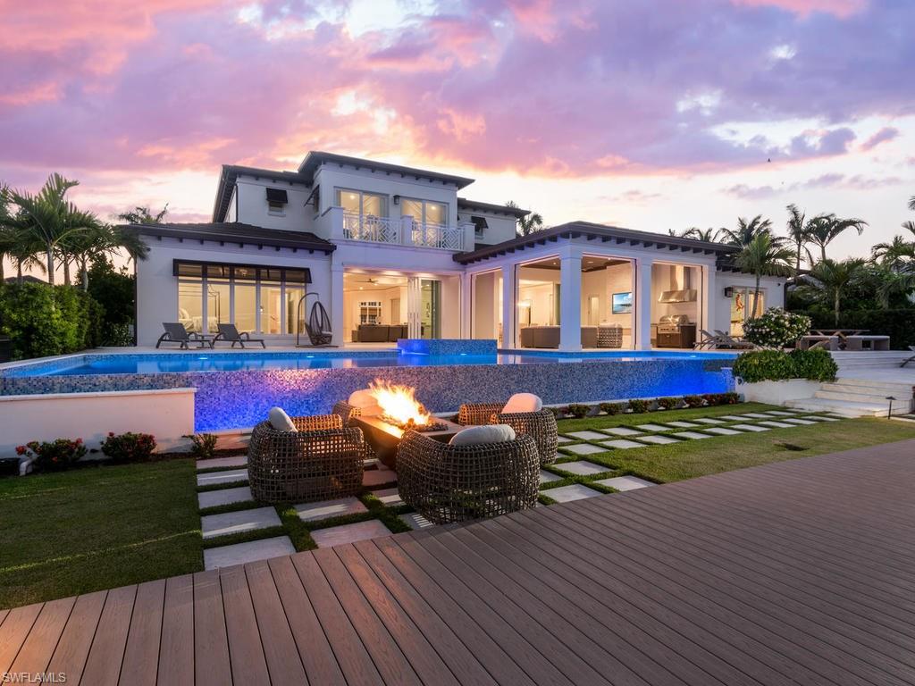 Sensational British West Indies inspired estate with resort level outdoor living to deliver the ultimate Aqualane Shores waterfront retreat. Greeted by an expansive motor court framed by an enchanting landscape design by ALD, the owners will enjoy an open layout with soaring ceilings that gracefully lead to the unbelievable outdoor entertainment and waterfront vistas beyond. Featuring a rare combination of 6 bedrooms and 6 and a half bathrooms, the custom Legno Bastone hardwood floors are perfectly accented by natural stone finishes and soft blue and green hues to communicate luxury and relaxation. The chef's kitchen has both a prep and serving island with Wolf and Sub Zero appliances. First floor master wing with separate his and her closets and great views over Heron Cove. One of a kind 53' infinity edge pool and spa with 84' custom Azek dock with boat lift and fire pit are unmatched. Two more first floor bedrooms with three bedrooms upstairs and lounge are perfect for larger parties. Whole home generator, elevator, Ruffino cabinetry and Elan A/V system complete this masterpiece. Truly one of Aqualane Shore's best homes is also steps to the beach and historic 3rd St South.