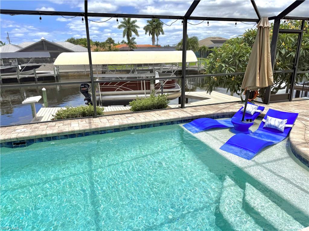 DIRECT GULF ACCESS pool home and NO FLOODING from past hurricanes! There are no bridges so it's great for sailboats too. Centrally located to all Cape Coral has to offer and easy access to Fort Myers. NO CARPET in this newly tiled 3 bedroom home with pool bath and remodeled master bath. Great room with vaulted ceilings, formal dining area and recessed den that can be used as an office or workout room. This home is being offered FURNISHED, NEW AC in 2021, NEW ROOF in 2018, NEW exterior paint 2026, and ALL ASSESSMENTS PAID. There are TWO covered lanais with outdoor kitchen and full size refrigerator. There are lots of slider doors to lead out to the beautiful pool area with tanning shelf, multi colored LED light, waterfall, and NEW pool heater. Walk down to your private, newly resurfaced boat dock with a 10,000 lb. lift, NEW canopy cover, and water and electric. You can feel secure with hurricane impact windows, accordion hurricane shutters for the lanais, and current flood insurance policy is transferable to the new owners. SECURITY CAMERAS stay with the home and Pontoon boat available for separate  purchase! Schedule your showing today!