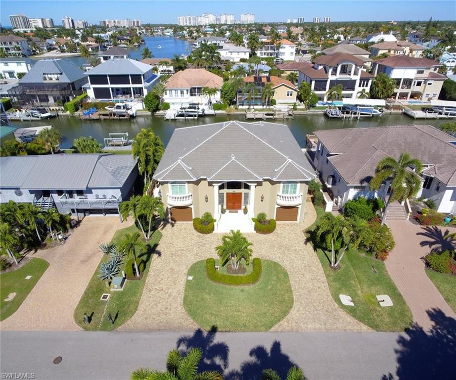 Immaculate waterfront home with elevator. A grand entrance leads to an open, light and bright elegant living area. Gorgeous views. Fabulous gourmet chefs kitchen with gas cooktop. Three en-suite BRs, office/den,  master suite with water views, new cabinets, countertops, tray ceiling, and bath. A wall of windows in the family room offer water views from every angle! Fabulous lower level bonus room for entertaining with wet bar, media lounge, office/BR, and full bath. 
 Two oversized one car garages.  Free form pool with spa, covered lanai lounge area, large exposed patio for sunning, and a dock with newly reinforced sea wall and boat lift make this a boaters dream home. Impeccably maintained. New roof and three new air conditioners as well as a new whole home generator, brand new washer and dryer, new sprinkler system and pool heater make this exceptional home HOT and priced to sell in this market. It is the lowest price per foot in Conners while being one of the most exquisite on the market. Near the Ritz Carlton, Mercado,Whole Foods. Walking distance to powdery white sand of Vanderbilt Beach, and only minutes to the Gulf of Mexico by boat. Great convenient location.