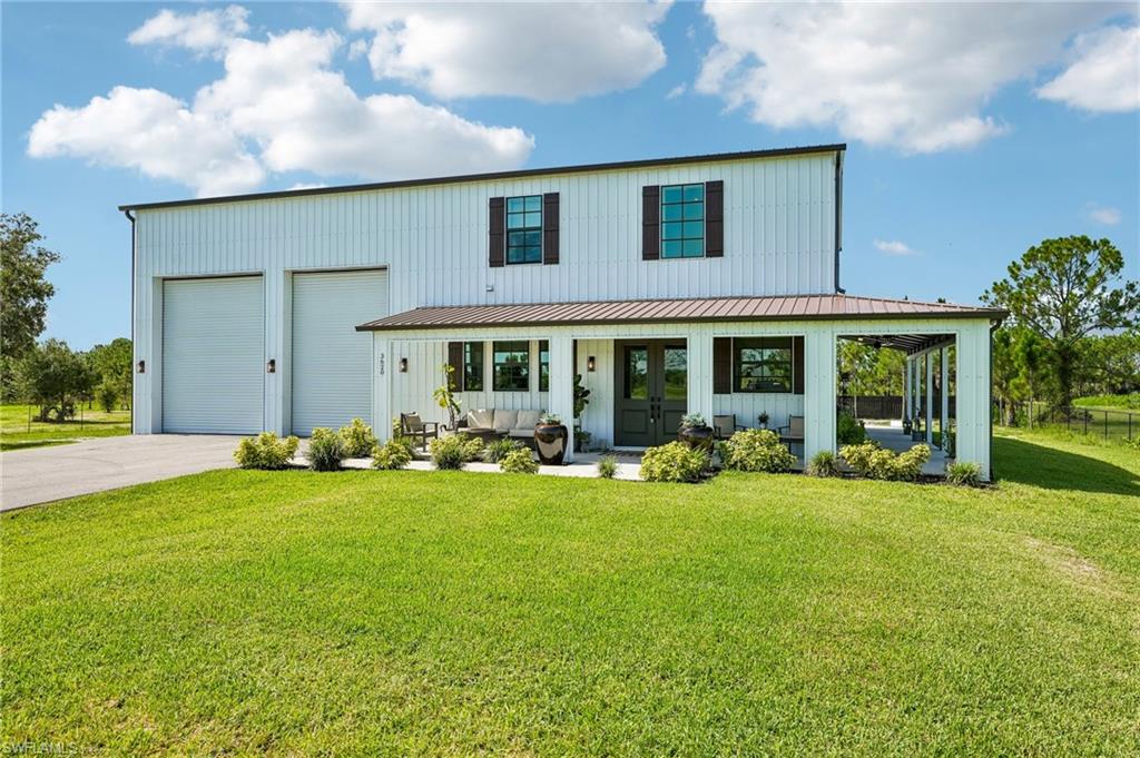 Exceptional craftsmanship and quality construction set this custom-built 2024 estate apart. Situated on a fully fenced and gated 2.58-acre, 100% uplands lot with no HOA, this beautifully designed property offers spacious living areas, outstanding functionality, and plenty of room for your boats, RVs, and all your toys!
One of the home's defining features is the impressive 1,200-square-foot drive-through garage, thoughtfully designed for car enthusiasts, hobbyists, contractors, and outdoor adventurers alike. Featuring three 14-foot roll-up doors, soaring ceilings designed to accommodate a vehicle lift, epoxy floors, space for up to five vehicles, and a 50-amp hookup, it's the ultimate space for storing boats, RVs, trailers, and recreational equipment or creating the workshop you've always envisioned.
A welcoming wraparound porch invites you to slow down and enjoy the peaceful surroundings, while multiple French doors fill the home with natural light and create a seamless connection between indoor and outdoor living. Inside, you'll find 3 bedrooms, 2.5 bathrooms, and a large versatile loft, complemented by 10-foot ceilings on the main level, 9-foot ceilings upstairs, and soaring 23-foot ceilings in the great room. A stunning floor-to-ceiling fireplace creates an unforgettable focal point, adding warmth and character to the heart of the home.
The kitchen is equally impressive, featuring quartz countertops, a custom wood vent hood, induction cooktop, double wall ovens, a built-in ice maker, built-in beverage refrigerator, apron-front sink, premium appliances, and a dedicated coffee bar. Custom blinds and window treatments provide the perfect finishing touch throughout.
Built with durable steel-frame construction, this home was engineered for exceptional strength, longevity, and energy efficiency, featuring impact-resistant windows and doors, spray foam insulation, and a whole-home reverse osmosis water filtration system for added peace of mind.
Whether you're relaxing in the spa, enjoying your morning coffee on the wraparound porch, or simply taking advantage of the wide-open space, this property offers the freedom to create the lifestyle you've been looking for. With ample room for a future pool, additional outbuildings, or a guest house, this exceptional estate is designed to fit your lifestyle today and for years to come.
A rare opportunity exists to purchase the neighboring newly built home as well, making this an ideal option for multigenerational living, extended family, or side-by-side ownership. Combining exceptional craftsmanship, spacious living areas, and outstanding garage capacity, this property truly offers the best of Naples living.