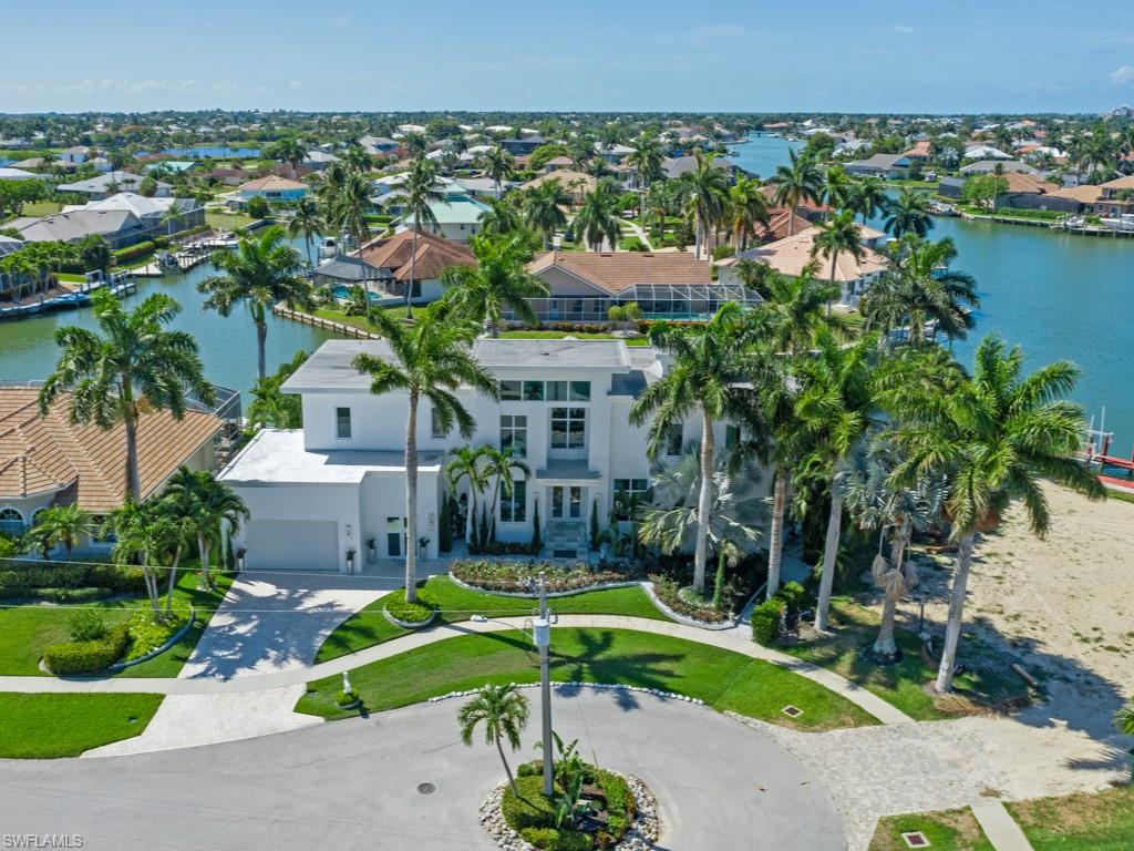 Contemporary mansion reminiscent of "coastal Miami" w/ minimalist design features on sunny SE exposure parcel! Recently brought to highest living standards w/ $250,000 in upgrades: new landscaping, new interior paint, new a/c, designer wallpaper in all baths, new bedroom furniture, new exclusive window coverings, 2 new custom seating areas, new LED daylight lights, bath features, Sunbrella umbrellas + more! 2 full stories of high quality construction, high ceilings, open floor plan, indoor/outdoor fireplace, gourmet kitchen, wet bar, artistic glass staircase, Italian tile, separate guest quarters, 10' impact sliders, a/c in garage! Astonishing private location w/multiple converging waterways & bay to further enhance the views & the benefit of having both sunrises & sunsets; you’ll adore full sun on the massive pool all day long & a bright, cheerful interior from the sunlight! Many lounging areas outdoors including a deck next to the salt water & zero edge swimming pool, a seating area next to the fabulous outdoor kitchen, a huge balcony for the master suite & guest quarters, plus extra dock space for waterside dining. Awesome separate dock area for your large boat, too!