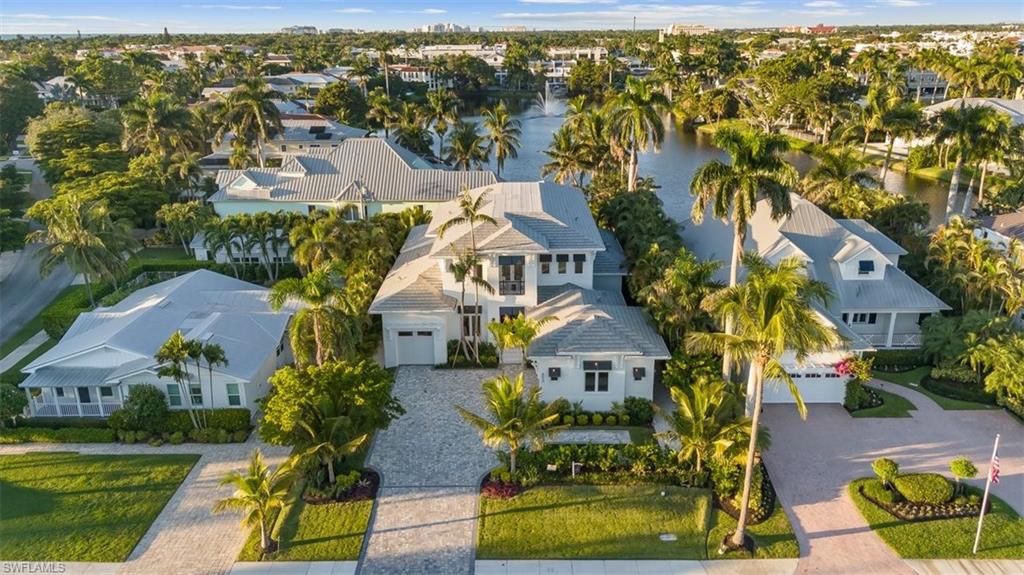 Experience the epitome of luxury living in this exceptional new construction home, perfectly situated in the heart of Olde Naples. Crafted by Refined Builders, this remarkable residence presents a rare opportunity to own a true masterpiece in one of Naples’ most coveted locations. Ideally positioned just minutes from the world-class dining and shopping of 5th Avenue South and 3rd StreetSouth, as well as Naples’ iconic beaches, this 4-bedroom + den, 5.5-bath home offers the perfect blend of luxury, comfort, and convenience—complemented by tranquil lake views from the 2nd floor and lush tropical landscaping. Wide-plank European oak floors and tongue-and-groove ceilings set a sophisticated tone, while the expansive great room flows seamlessly into a stunning gourmet kitchen featuring a quartz-clad center island, sleek two-tone cabinetry, and a full suite of premium Thermador appliances—ideal for both everyday living and elegant entertaining. Sliding glass doors lead to your private outdoor sanctuary, complete with a resort-style saltwater pool and spa, custom summer kitchen, and a spacious covered lanai—perfect for seamless indoor-outdoor living. The first-floor primary suite is a luxurious retreat with direct pool access and a spa-inspired bath featuring a soaking tub, oversized walk-in shower, and dual vanities. Upstairs, three ensuite guest bedrooms—including a VIP second master—are accessible via stairs or a private elevator. A bonus living room with wet bar, scenic balcony, and captivating lake views provides a relaxed space to unwind or entertain. Additional highlights include dual laundry rooms, a 3-car garage, tankless water heater, whole-house generator, and propane tank.