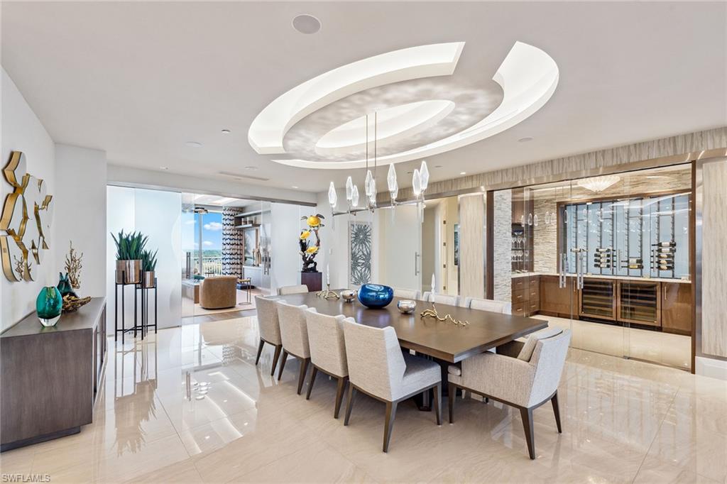 Majestically atop Aqua at Pelican Isle, this rarely available furnished penthouse is the epitome of sophisticated living. Go directly into this exquisite home boasting over 6,600 square feet under air and 9,453 square feet total. Enjoy luxurious living spaces with views of the Gulf to the west and Kinsale Golf Course views to the east. This penthouse offers indoor-to-outdoor entertaining spaces. The 1,315-square-foot entertaining outdoor terrace has an outdoor kitchen including an ice maker and beverage refrigerator, sitting area with heaters, grill (never used) and a million-dollar view, which cannot be overstated. No expense was spared in this custom home to bring the finest craftsmanship and unique one-of-a-kind features. This residence offers custom ceiling treatments, luxurious lighting, remote shades on all windows and doors, marble/wood flooring, an enclosed, temperature-controlled wine room, humidor and quartz countertops with custom light features. The open concept grand salon blends seamlessly with the gourmet kitchen with top-of-the-line appliances, two dishwashers, sleek custom quartz countertops and a large entertaining island/sitting area. A separate custom bar area with an icemaker, sink, refrigerator and beautifully designed cabinetry creates the epitome of entertaining. A separate glass-enclosed family room and spacious formal dining area complete these well-thought-out areas. There are three guest e-suite rooms, each unique with countless features. The primary suite has two separate built-out closets, stunning views of the gulf, a large bath with dual sinks and a spacious shower plus a soaking tub. Two of the guest suites are used as offices but can instantly be returned to bedrooms with little or no additional work. Hurricane shutters on all outdoor terraces provide peace of mind protection. An enclosed oversized two-car garage comes with this residence plus additional storage space in garage as well as in the service hall of the residence. Aqua is amenity-rich with 24-hour security, kayaks, two social rooms, golf simulator, outdoor putting green, two dog parks, fitness and theater, just to name a few. This home was meticulously designed and completed in 2023 by Collins and Dupont with the purpose to wow you! Seller is offering membership to the Pelican Isle Yacht Club (next door). This membership includes shuttle to the beach, restaurant, pool, tennis, pickleball and bocce. A 55-foot boat slip in the Aqua Marina (only five minutes out to the Gulf) is available.
