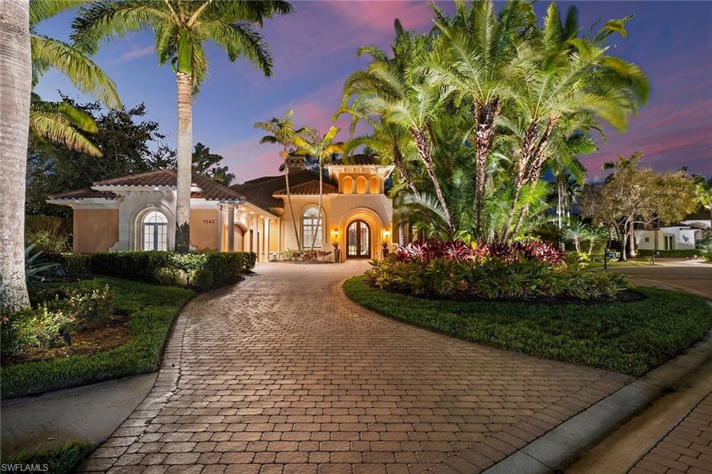 On a quiet cul-de-sac in The Classics Plantation Estates at Lely Resort, this custom-built turnkey-furnished residence is on an oversized homesite with more than 140 feet of lake frontage and southwest exposure overlooking long water views and the 18th hole of the Classics Golf Club.  The residence offers approximately 5,080 square feet of air-conditioned living space with four bedrooms plus a den and four-and-one-half baths. Each bedroom features an en-suite bath, creating privacy and comfort for residents and guests. Interior finishes include oak and bamboo flooring, tray ceilings, double and triple crown molding, custom millwork, solid core doors, plantation shutters, impact-rated windows and doors and custom cabinetry throughout. Designed for everyday living and entertaining, the kitchen is equipped with professional-grade appliances, a central island, granite countertops, walk-in pantry, breakfast bar, warming drawer, wine cooler and three dishwashers. A fully equipped outdoor summer kitchen with built-in grill extends the entertaining space to an enclosed lanai. The primary suite offers two large walk-in closets with custom organization systems and a spacious bath with soaking tub, dual vanities and a walk-in shower with multiple shower heads. Outdoor living spans the length of the home and includes a custom-designed heated pool and spa with travertine decking, an open-air pergola and expansive covered seating areas that capture panoramic lake and golf course vistas. Additional features include three updated air conditioners, a walk-in laundry room, two whole-home water filtration systems, a circle drive leading into an oversized three-car garage and a roof installed in 2019. Residents of Lely Resort enjoy access to premier amenities, including three championship golf courses and The Players Club and Spa, which offers resort-style pools, spa services, tennis, pickleball, bocce, fitness facilities and multiple dining venues. The community is just minutes from downtown Naples, Marco Island and Gulf beaches.