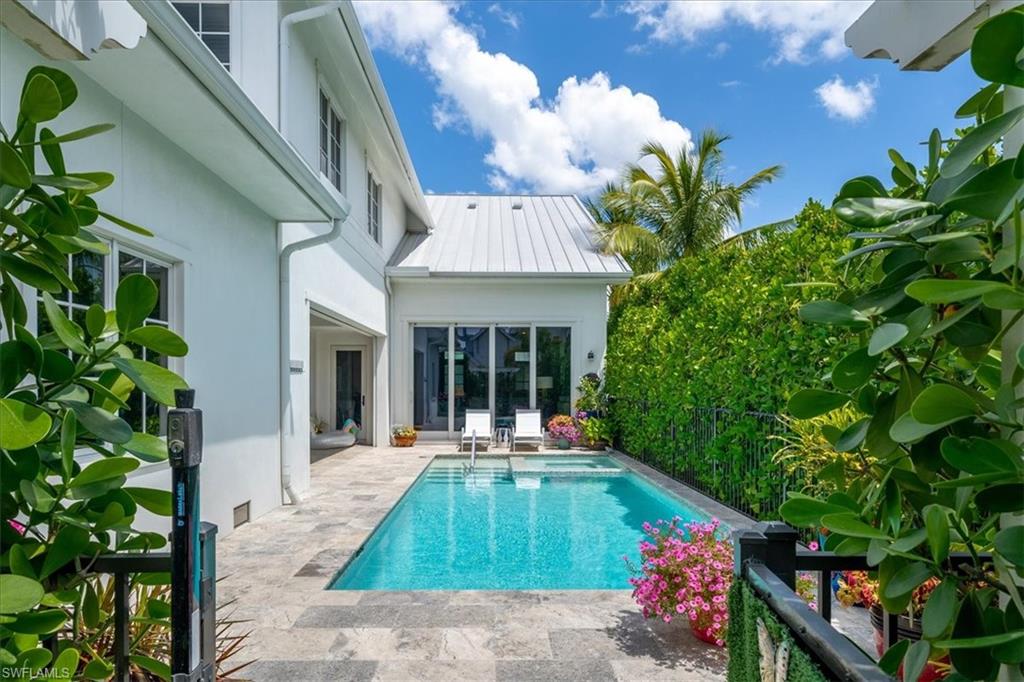 Nestled in the heart of downtown Naples within the prestigious waterfront community of Mangrove Bay, it's just a stone's throw away from Baker Park, the Gordon River Greenway, and a short stroll from the shopping and dining delights of 5th Avenue South. With a private boat dock included, this 2017-built residence boasts over 3,200 square feet of living space, featuring four bedrooms and three and a half baths. The ground floor hosts a luxurious primary suite, seamlessly blending an open-concept layout designed by MHK Architecture with elements of Old Florida charm, such as soaring ceilings and oak wood flooring. The chef's kitchen is equipped with a top-of-the-line Thermadore appliance package, including a natural gas range. The home also boasts three spacious guest suites, one of which includes a private living space, morning bar, and bath. Its southern-facing corner lot floods the interior with natural light, enhancing the seamless indoor-outdoor living experience. Glass sliders lead to an outdoor oasis with a tropical pool, spa, covered patio with a gas fireplace, grilling station, and electronic screen protection. The property is beautifully landscaped and includes a two-car garage with provisions for an electronic car charging station. Residents enjoy access to Mangrove Bay's luxury amenities, including a Wellness Center with a fitness area, kayak/paddleboard storage, and a private boat ramp. Plus, low-maintenance living is facilitated with comprehensive resident services like landscaping, pool care, and dock maintenance.