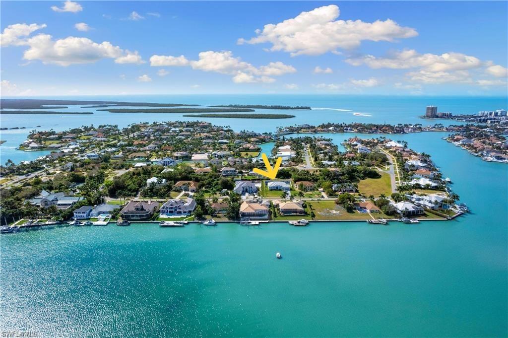 LOWEST PRICED NEWER CONSTRUCTION SINGLE FAMILY HOME ON HALF ACRE LOT IN MARCO ISLAND! Exquisite Coastal Estate – Steps from the Gulf, Half-Acre Lot, and Fully Customized. This stunning 4-bedroom plus den, 3-car garage residence sits on a rare half-acre homesite in one of the most exclusive estate neighborhoods near Marco Island—just steps from the shimmering waters of the Gulf. Caxabas & San Marco Marina are just minutes away! Built with elevated design and having sustained no hurricane damage, this home offers the perfect blend of safety, sophistication, and seaside luxury. Inside, you’ll find soaring vaulted ceilings and a bright, coastal-inspired interior that’s filled with natural light. Wide-plank tile flooring runs throughout, anchoring an open layout that flows effortlessly from the living area to the dining area to the entertaining space. The custom kitchen is a chef’s dream, complete with quartz countertops, sleek white cabinetry, double wall ovens, and a large island perfect for gathering. A built-in wet bar adds a touch of elegance, ideal for hosting or everyday enjoyment. Glass sliders open to an expansive covered lanai, where an outdoor kitchen, TV lounge, and a custom-designed pool and spa with elegant water features create your own private resort. A 500-gallon underground propane tank fuels the built-in BBQ & generator. The oversized yard is beautifully landscaped, offering space and privacy rarely found this close to the Gulf. The primary suite is a true retreat, featuring direct access to the outdoor living space, dual walk-in closets, and a luxurious spa-style bathroom with a glass-enclosed walk-in shower and a dramatic freestanding soaking tub. A dedicated home office with large windows provides inspiring views and abundant natural light, making it a productive and peaceful workspace. This is a rare opportunity to own in a high-end coastal enclave with no HOA restrictions, quick access to the open Gulf waters, and every feature today’s buyers are looking for. Whether you’re seeking a full-time residence or a high-performing rental investment, this home delivers on all fronts — location, design, and lifestyle. One or more photo(s) has been virtually staged, AI-generated, or rendered.