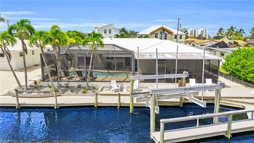 STUNNING NEWLY REMODELED GULF-ACCESS CANAL HOME WITH POOL & DEEDED BEACH ACCESS & 20k BOAT LIFT! Experience luxury coastal living in this expansive 4-bedroom, 3-bath, 1,928 sq. ft. pool home ideally situated on a Gulf-access canal in the highly sought-after Fairview Isles community. Completely remodeled down to the studs, this open-concept residence showcases impeccable craftsmanship, high-end finishes, and modern coastal elegance throughout. The home features new plank tile flooring, a fully redesigned kitchen with new cabinetry, an oversized statement island, quartz countertops, and top-of-the-line appliances—perfect for entertaining and everyday living. A desirable split-bedroom floor plan offers both a Primary Suite and Junior Primary Suite, each with pool views and spa-inspired en-suite baths featuring designer tile and large walk-in showers. Outdoor living is exceptional with an expansive pool and deck area, ideal for entertaining, relaxing in the Florida sunshine, and enjoying tranquil canal views. Boating enthusiasts will appreciate the newly upgraded boat lift with 20,000-lb motors, a private dock with brand-new Trex composite decking, and quick, direct access to the Gulf of Mexico. For added peace of mind, expandable flood barriers have been installed, offering a ready-to-use solution for door protection that can be quickly and easily deployed in advance of storm conditions. Additional highlights include a two-car garage, a spacious interior laundry room, and numerous recent upgrades throughout. Fairview Isles offers deeded beach access, just a short stroll to the sugar-sand beaches and dreamy sunsets of Fort Myers Beach. Ideally located on the south end of the island with convenient access to Naples, Bonita Springs, restaurants, golf courses, and RSW International Airport. This exceptional home delivers the ultimate boating and beach lifestyle, blending luxury, location, and peace of mind in one remarkable offering. Welcome home.