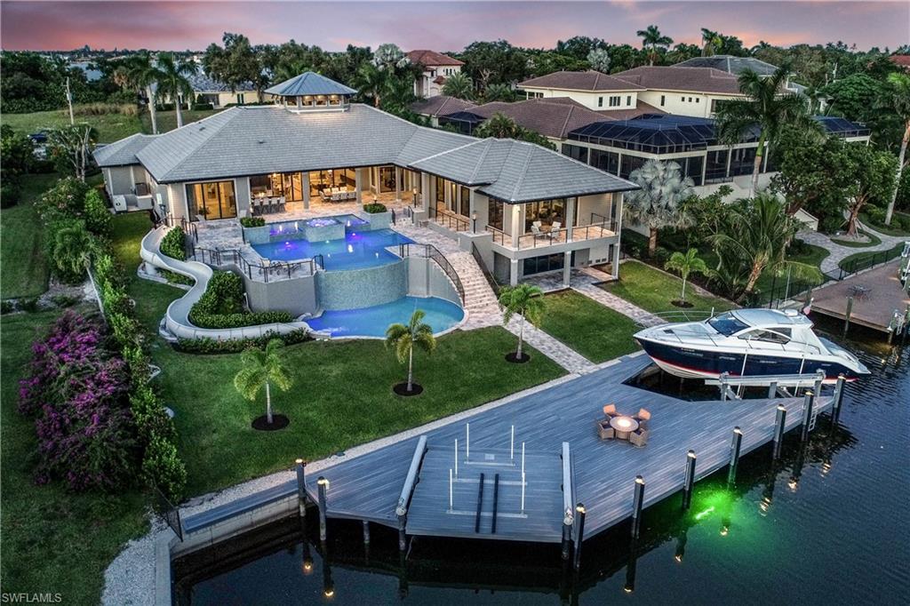 H.13734 - ONE OF A KIND!!!! IN THE HEART OF THE ESTATES WITH MINUTES TO THE GULF A 2017 YOUNG BEAUTIFULLY FURNISHED AND OF EXTRAORDINARY CALIBER ONE LEVEL SOUTHERN EXPOSURE HOME POSITIONED ON A 250’ DEEP LOT WITH FEATURES THAT WILL CAPTURE YOUR ATTENTION!! YOU WILL NEVER LEAVE YOUR RESORT BACKYARD WITH A CUSTOM WATER SLIDE THAT TRANSCENDS THE 17’ ELEVATION ALONG SIDE A 3 LEVEL POOL WITH INFINITY EDGES. SUN TERRACES ON EACH LEVEL. EXQUISITE 5 BEDROOMS, 5.1 BATHS, INCLUDES  GUEST SUITE W/ 2 BDRMS, 2 BTHS, LIVING ROOM, REFRIG.,MICRO, DW AND  WASHER AND DRYER,  GAS COOKING  BOTH AT THE  OUTDOOR KITCHEN AND GOURMET MAIN KITCHEN, MULTI REFRIG'S, DW’S, CONTROL 4 MANAGES HOME, WINE COOLER WET BAR, STUDY WITH ELEGANT BUILT IN, SUPER LARGE LAUNDRY WITH LARGE ISLAND THAT CAN BE AN CATERING CENTER OR ARTS/CRAFT STUDIO, CEILING TREATMENTS AND MOULDINGS ABOUND, IN ADDITION TO ALL OF THIS A 1200 SQFT AC STORAGE ROOM ON THE LOWER LEVEL. OVER-SIZED 4 CAR GARAGE, 30KW GENERATOR, 1000 LB PROPANE TANK BURIED, GATED AND FENCED AND SO MUCH MORE.  SEAWALL 2016. DOCK W/ ONE LIFT 30,000 LB AND THE OTHER 10,000 LB HYDRAULIC LIFT FOR EASE OF KAYAKS, WAVE RUNNERS, ETC. MUCH, MUCH MORE!!!