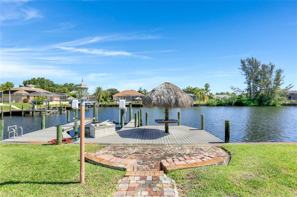 LOCATION, LOCATION, LOCATION! Located in one of the most desirable neighborhoods in SW Cape Coral, this open floor concept features a kitchen with lots of cabinetry, Granite Counters, and Stainless Steel appliances. Tile floors throughout the home. Freshly painted with Crown Molding and lots of natural light. OVERSIZED LOT (12,001 SQ FT) with a deep backyard that leads to a dock with boat lift and tiki hut.  Pool was put in 2018.  Pavers in all surrounding areas: driveway, large entry way, pool area and walkway to dock. All assessments paid!  Just minutes away from great restaurants, entertainment and shopping. Even by boat, you are minutes away from Rum Runners, and then it’s a clear path to Sanibel/Ft Myers beaches/islands and some of the best fishing and boating in SW Florida. Just around the corner is Sands Park, to be completed in 2022, with its multiple sport courts, playground, picnic areas, fitness stations and more. Sold Turnkey, so sit back and relax by the pool and enjoy beautiful sunsets in your “Piece of Paradise”.