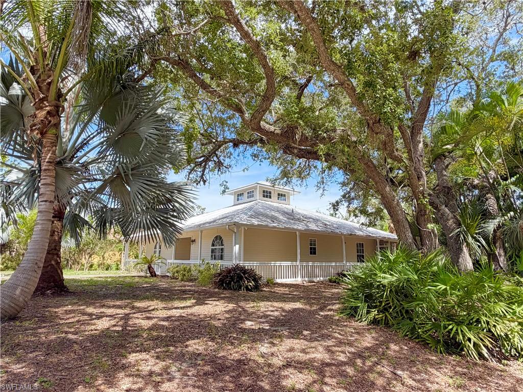 One or more photo(s) has been virtually staged, AI generated or rendered.  This home offers a great opportunity to own a large corner property just minutes from Bonita Beach with tons of potential on .31 acres!  With mature Oak and assorted Palm trees creating privacy, this charming 3 Bedroom, 2 bathroom home with a complete wrap-around porch with a completely repainted interior, light and bright.  Step into the great room with high vaulted ceilings offering an abundance of natural light from the window dormer and a very open layout at the heart of the home.  Master bedroom retreat with oversized ensuite bathroom and walk-in closet.  Two other guest bedrooms provide versatility to set up as an office or Den, if desired.  The open kitchen offers the same high vaulted ceilings with a large breakfast room surrounded by windows and direct access to the back screened in lanai via the breakfast room or great room.  Other exterior features include the partially screened-in wrap around lanai and a detached 2-car garage to access from West side of property.  There is also multiple car parking spaces in front of the home in designated gravel area.  Just steps away from the property is a natural creek that runs along Luke Street to your West, providing no immediate neighbors along the side.  With easy access right off of Bonita Beach Road, the location of this property is hard to beat with the beach, restaurants, shopping and much more, all just walking or biking distance away!