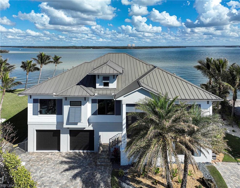 This 2 Story Custom Coastal bay front home sits on what is perhaps the best bay lot in all of Fort Myers Beach and offers: nearly 200’ of seawalled bay frontage of turquoise waters with the pass to the Gulf of Mexico immediately to the west, ultimate exposure - south, southeast and southwest provides sun on the pool all day and natural light throughout the home, just a short walk to one of Ft Myers widest & most beautiful beaches, premier boating from your private dock with lifts for two boats plus jet skies and kayaks and only a couple of minutes to the Gulf, a beautiful concrete home with impact windows and doors, huge garage space for 4 cars and toys, private elevator, 4 bedrooms 4 baths, open floor plan with wide and long bay views from everywhere, rare “live completely on one level” plan, kitchen open to large great room with gas fireplace, dining room on the water, an expansive covered lanai with stairs leading to the pool and spa right on the bay, a custom fire pit area, and large yard area for kids, grandkids and pets,  Other features include quality millwork, builtins, solid interior doors, custom wood kitchen cabinetry, large island, 48” gas range, fantastic bedroom and bath with custom closets and an amazing recreation room for family & friends parties and everyday fun!  This home is located at the very southern tip of Fort Myers Beach for easy access to the many restaurants, shopping, entertainment venues and golf courses in Bonita Springs and Naples.