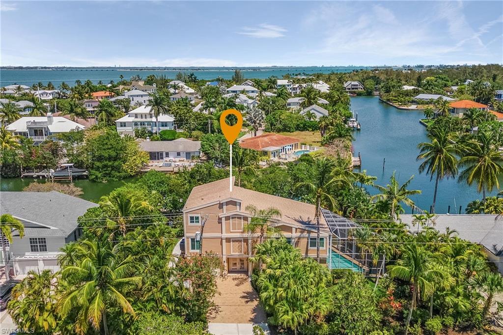 Welcome to your tropical oasis on beautiful Sanibel Island. Impeccably maintained Gulf access pool home is a boater’s delight, just minutes to the crystal blue waters of the Gulf of Mexico. Enjoy watching dolphins and manatees play and keep your boat on the 20,000 lb lift. Very private location with amazing views of the canal and Ding Darling across the street! This light and bright multi-level home is coastal inspired with walls of glass and soaring vaulted ceilings to the top floor. The updated kitchen has custom wooden cabinetry with exotic level granite, ss appliances, built-in wine fridge and opens to the living and dining areas. Enjoy morning coffee while watching the sunrise on your private balcony. Two spacious guest bedrooms and a guest bath complete the main floor. The master overlooks the main living room with a Juliet balcony overlooking the canal. Spa like master bath with oversized shower with 2 shower heads. Enter through the finished lower level of the home with an added bonus area that could be used as a cabana (pool is directly off this space), den, game area, or media center – also has a full bath. Oversized garage. Nothing to do but enjoy your new island life!