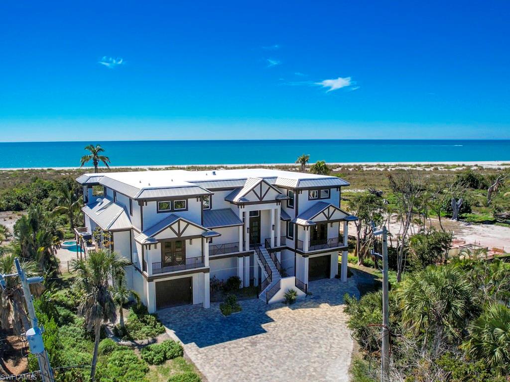 Step into the definition of coastal elegance with this custom-built masterpiece, completed in 2021, directly located on the shores of the Gulf of Mexico in the sought-after Chateaux Sur Mer neighborhood. This 5-bedroom, 5.5-bathroom residence, inclusive of a home office, is a celebration of top-tier craftsmanship and luxury. The chef's kitchen with imported granite and exquisite tilework sets the stage for culinary excellence. An open-concept living space features a stunning gas fireplace, creating a warm and inviting atmosphere. The living area seamlessly extends onto a porch, where the pool and the Gulf of Mexico beckon beyond—a true sanctuary for enjoying nightly sunsets. The primary suite boasts a morning kitchen, deck access, and a spa-like bathroom adorned with a tub, separate shower, and custom tilework. The convenience of a large garage with abundant storage space, coupled with an elevator providing access to all levels, ensures both practicality and luxury. Indulge in beachfront bliss with a private path leading to the pristine shores. This residence is a harmonious blend of modern sophistication and coastal charm.