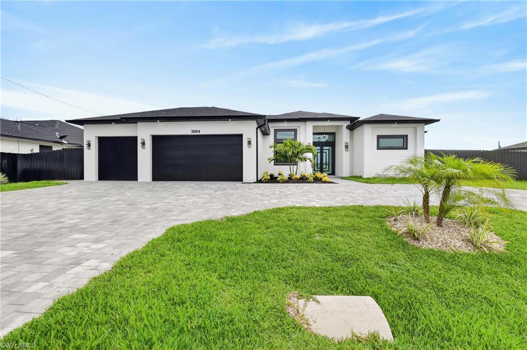 Triple lot new  construction single-family home located in one of Cape Coral’s most desirable areas. This modern residence sits on an oversized triple lot and features a spacious triple-car garage, offering plenty of room for future projects and expansion. Designed with high-end finishes throughout, this home blends contemporary style with functionality, making it ideal as a primary residence or investment. The property offers 4 bedrooms and 3 full bathrooms, highlighted by a spectacular chef’s kitchen with premium cabinetry, elegant finishes, and a built-in bar perfect for entertaining. The outdoor living area is a true Florida retreat, featuring a covered patio, for year-round enjoyment,  outdoor kitchen, ideal for both summer evenings and cooler nights. This home delivers the ultimate Florida lifestyle. Additional highlights include city water and sewer and not located in a flood zone, providing peace of mind and added .