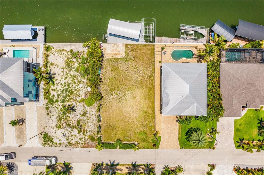 Some of the best gulf access on Pine Island.  Be in San Carlos Bay in less than 5 minutes.  From there you can access all the outer islands, restaurants, bars, some truly great fishing and the beautiful beaches of Sanibel, Captiva, Fort Myers, and Cayo Costa. Hop in your car or golf cart, ride your bike, or walk to the local restaurants and bars available in St James City, including Phuzzi's, The Waterfront, The Low Key Tiki, and Froggy's. This lot is cleared and filled.  It has 2 boat lifts, one 16,000# and one 8,000#.  The larger of the two lifts has a cover and the smaller one has the frame, but no canopy.  There is also a small lift for kayak that probably needs a new motor, and a paver patio adjacent to the large wrap around composite dock.